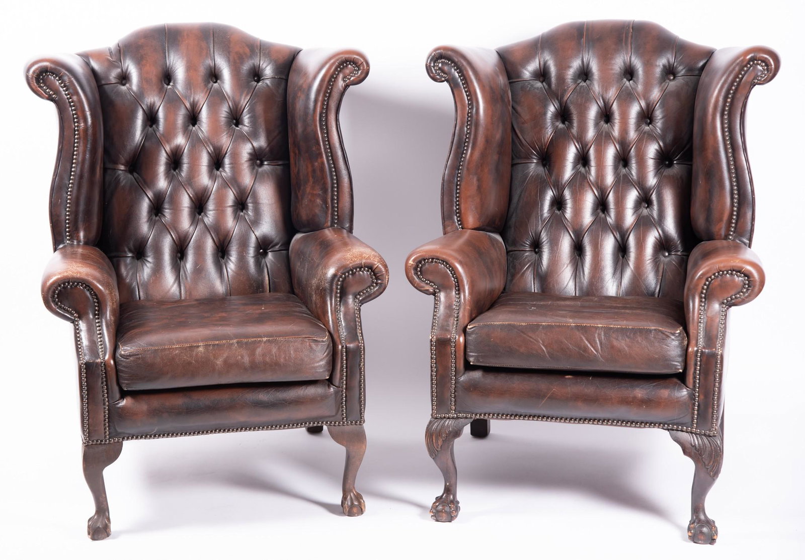 Pair Of Burgundy Wingback Armchairs With Button Back Leather Upholstery: Pair Of Burgundy Wingback Armchairs With Button Back Leather Upholstery Raised on claw and ball feet.