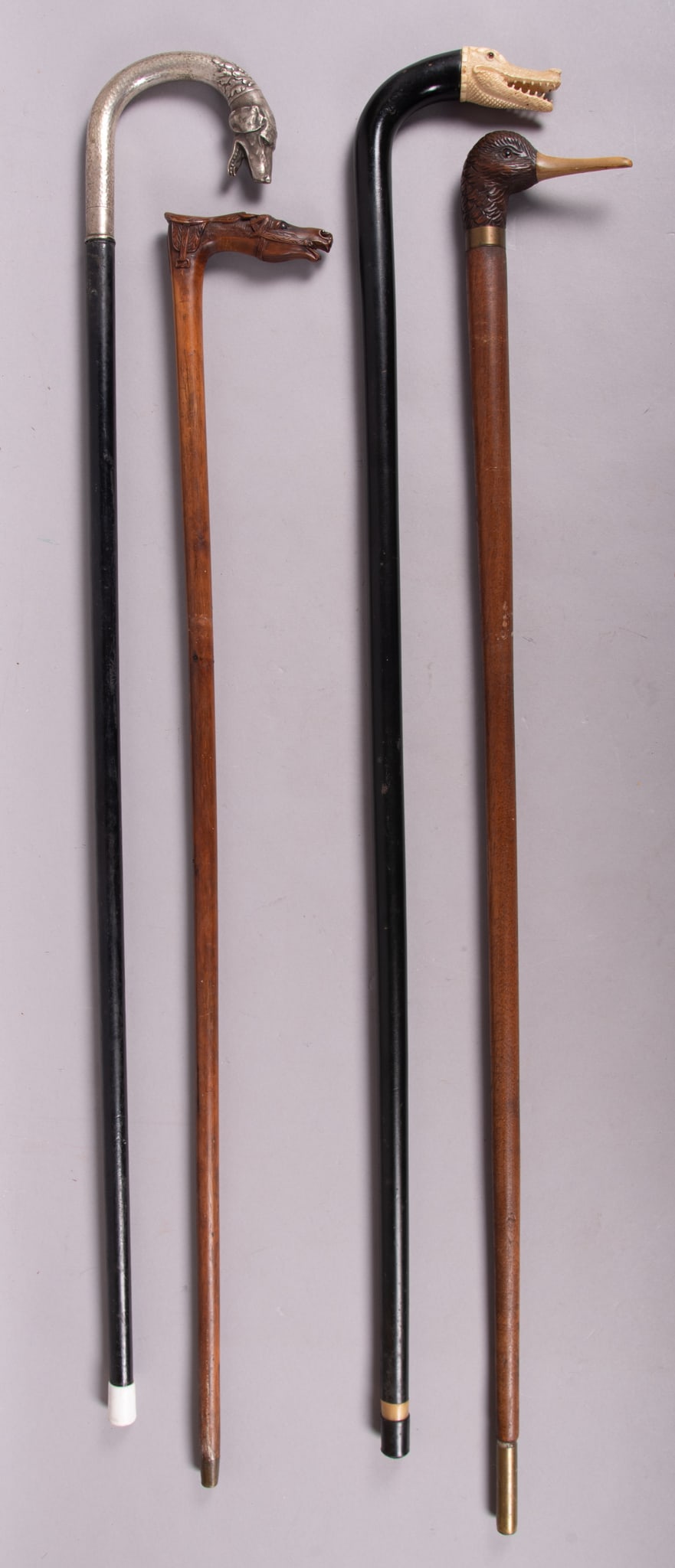 Collection of Four Walking Sticks with Animal Head Handles: Collection of Four Walking Sticks with Animal Head HandlesVery nice collection of four wood canes each with a different animal head for handles. Included is a (1)black lacquered shafted cane with a ce