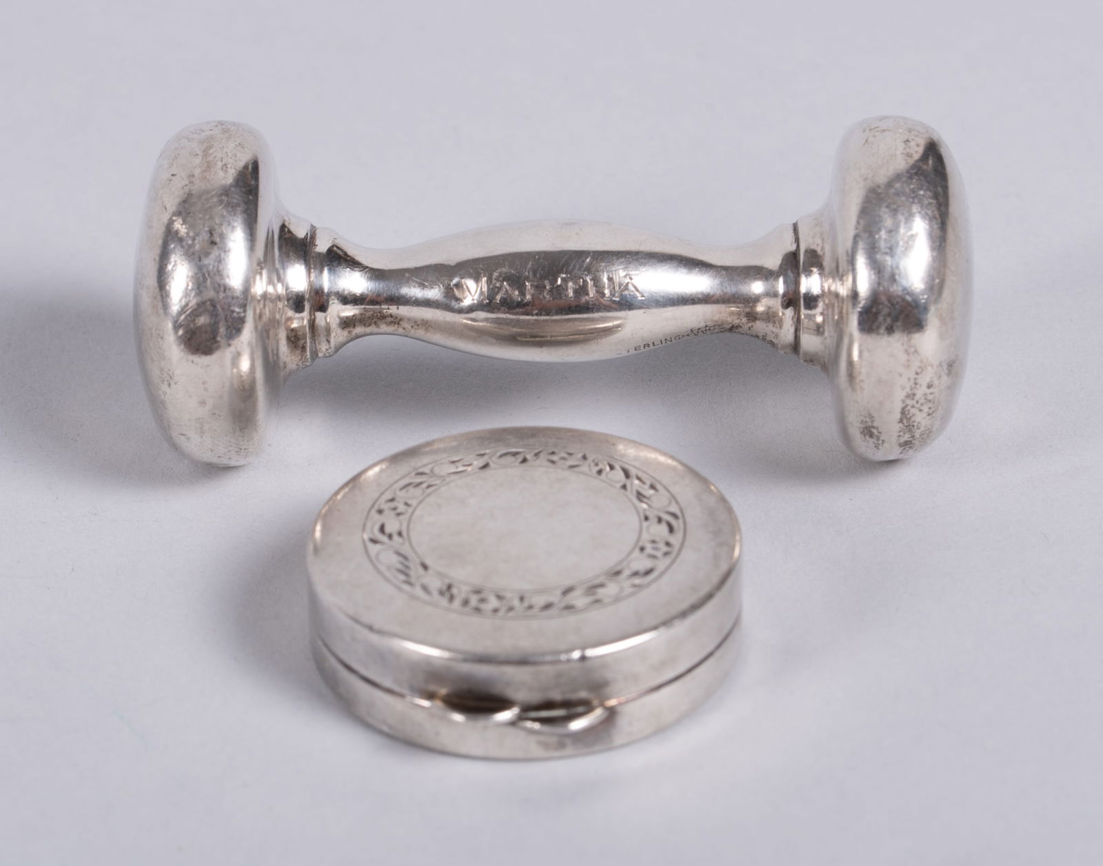 Antique Sterling Baby Rattle and Pill Box: Antique Sterling Baby Rattle and Pill Boxrattle marked sterling and engraved Martha, length 3 inches; together with sterling pillbox, diameter 1 1/2"; total weight 1.560 troy ounces.