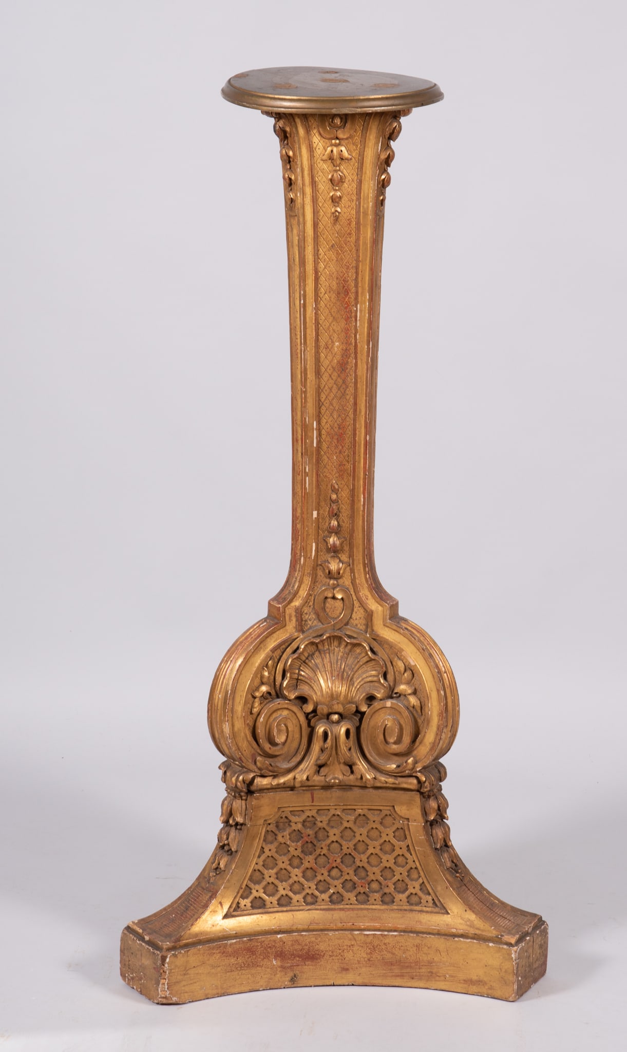 A French "Belle Epoque" Style Gilded Pedestal: A French "Belle Epoque" Style Gilded PedestalA tall triangular shaped gold leafed pedestal, the surface decorated in stylized shells and floral vines. Approximately 46 inches tall.