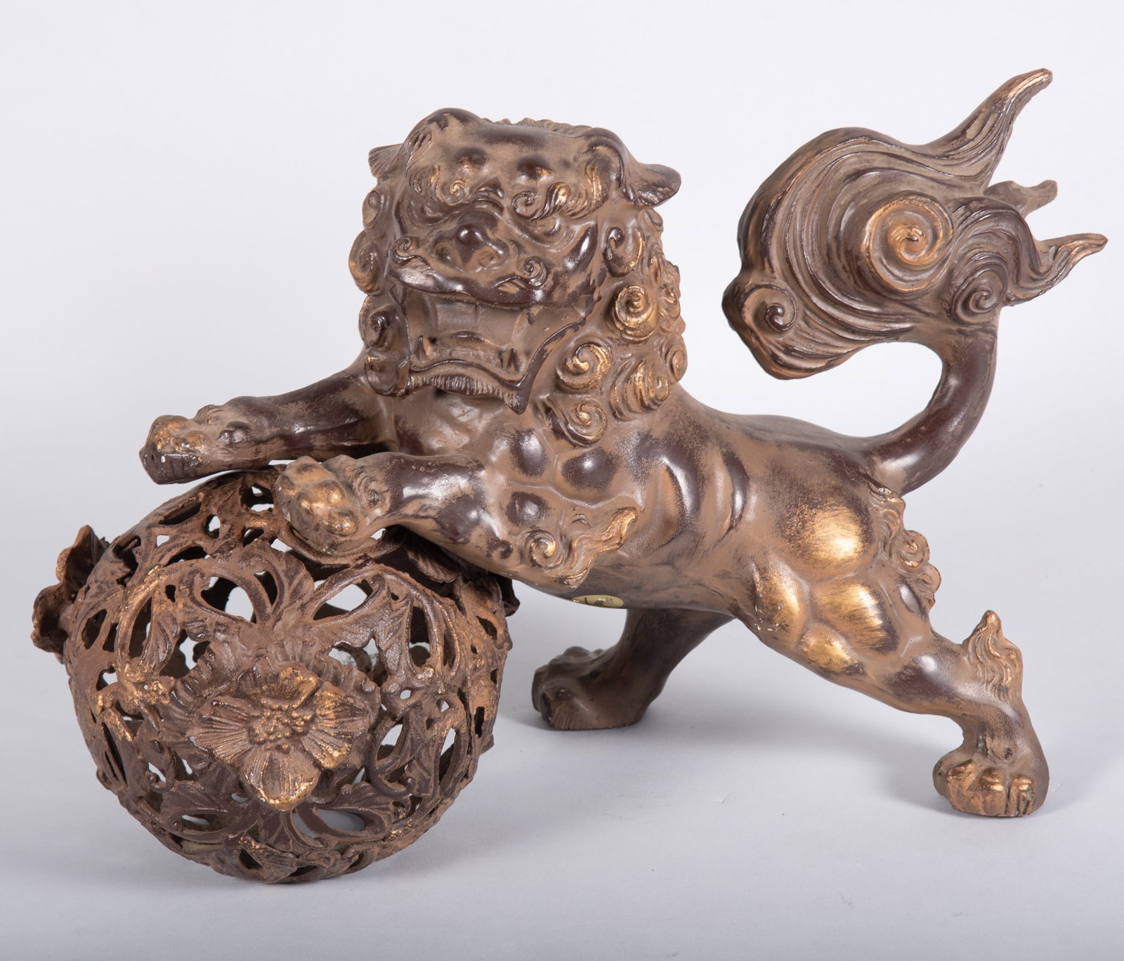 Metal Sculpture of a Chinese Temple Lion Plating with a Ball: Metal Sculpture of a Chinese Temple Lion Plating with a Ball Nice metal sculpture with a bronze patina depicting a Chinese ?Fu? lion playing with a vine ball with peony flowers. Ball is separated from
