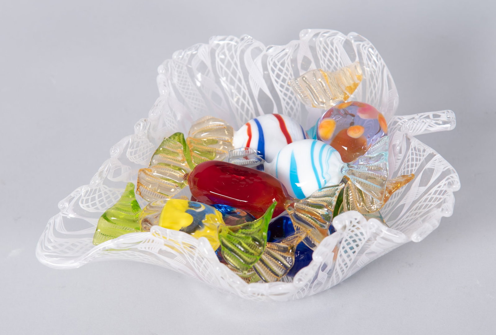 Paolo Venini (1895 - 1959) Venini Art Glass Fazzoletto Handkerchief Bowl Together With Nine Venetian: Paolo Venini (1895 - 1959) Venini Art Glass Fazzoletto Handkerchief Bowl Together With Nine Venetian Glass Wrapped Candies bowl in the shaped of a leaf with stem, 1 3/4 x 6 x 5 inches; nine colorful v