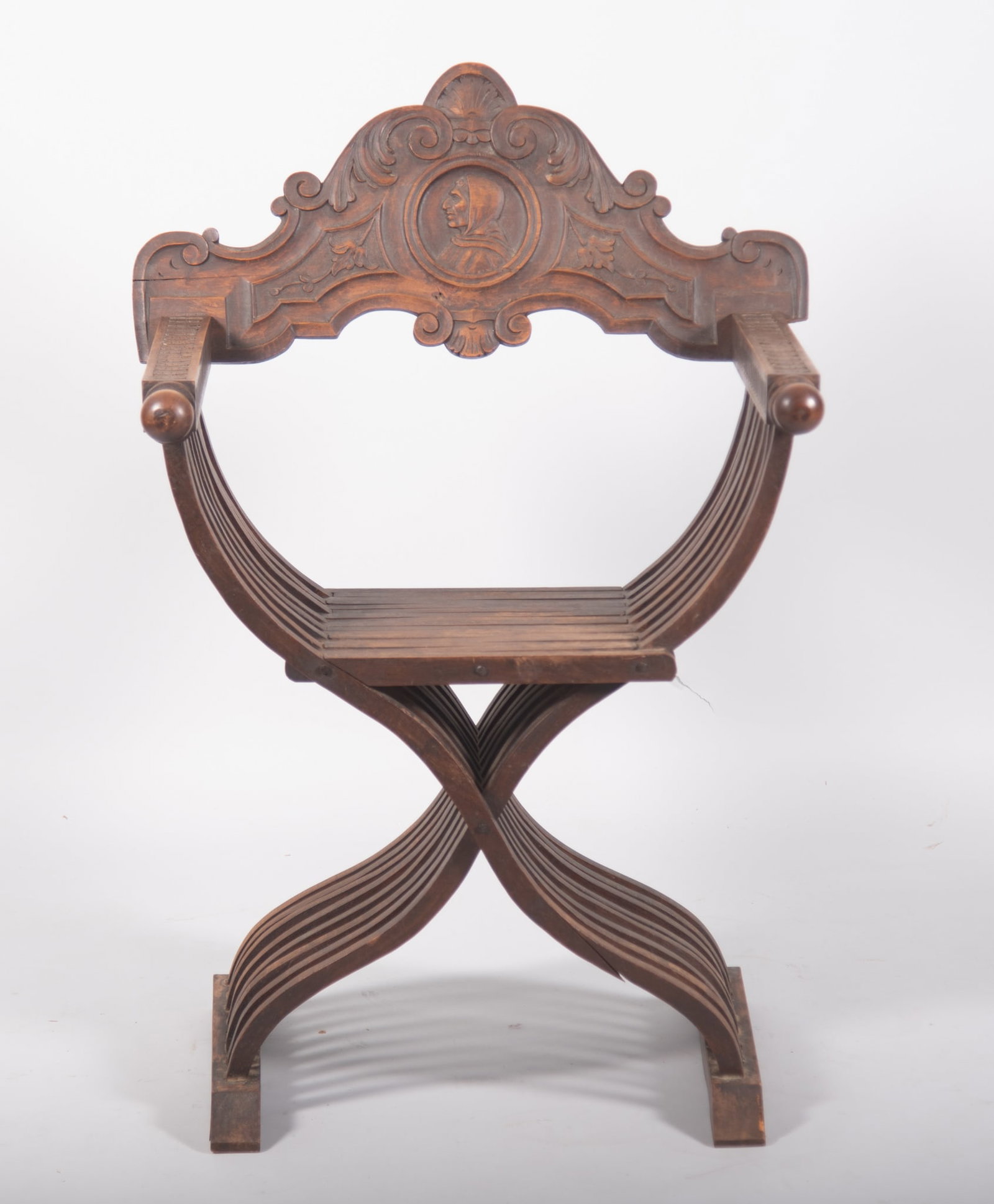 An Italian Renaissance Style Savonarola Chair: An Italian Renaissance Style Savonarola Chair Italy, 19th century, the Savonarola with carved face to the back panel.