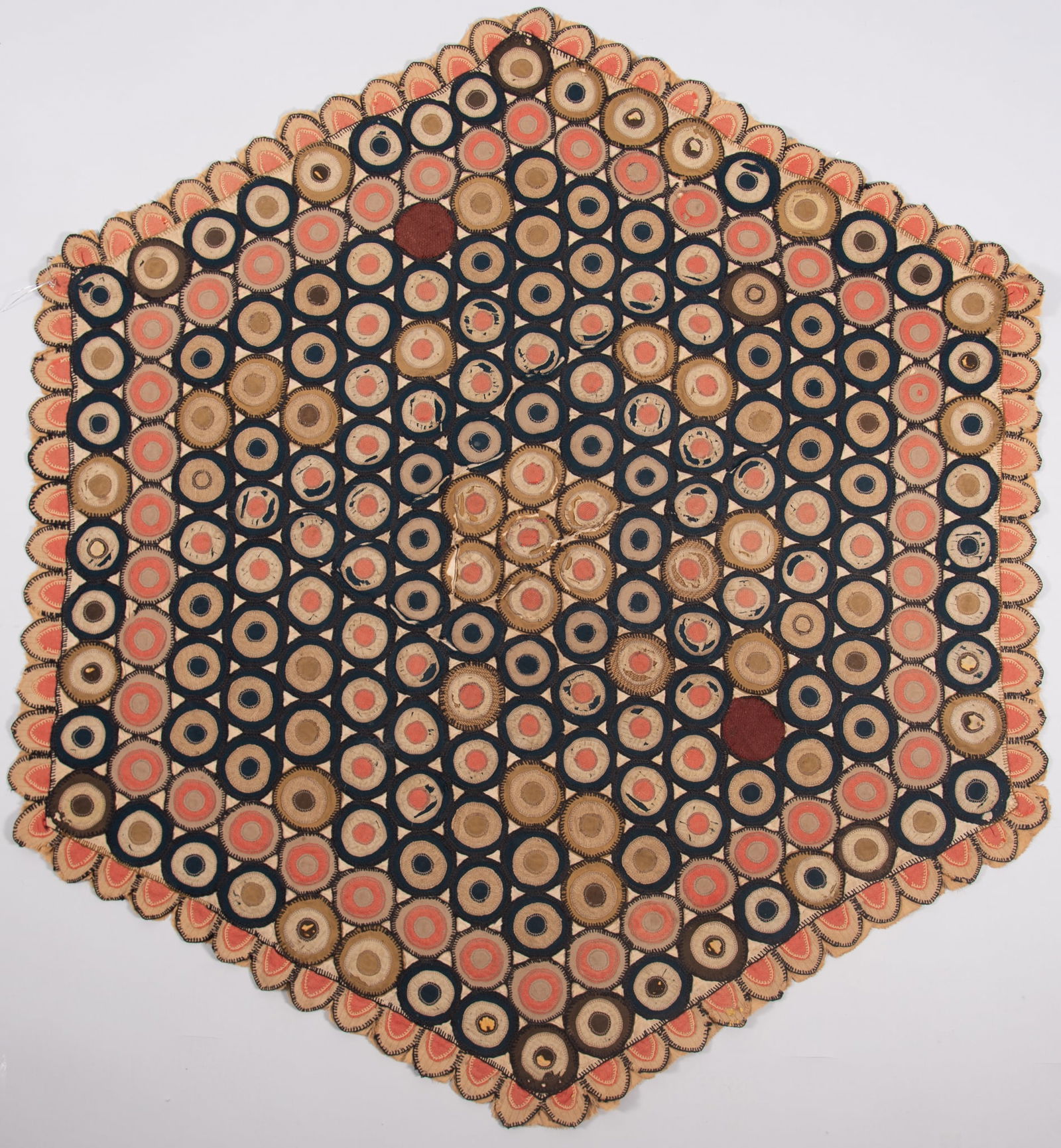 Late 19th Century Fabric Penny Rug: Late 19th Century Fabric Penny RugThis late 19th century, circa 1890, hexagon shaped penny rug is made of several pieces of different fabric textures sewn in connecting circles. Each circle has two sm