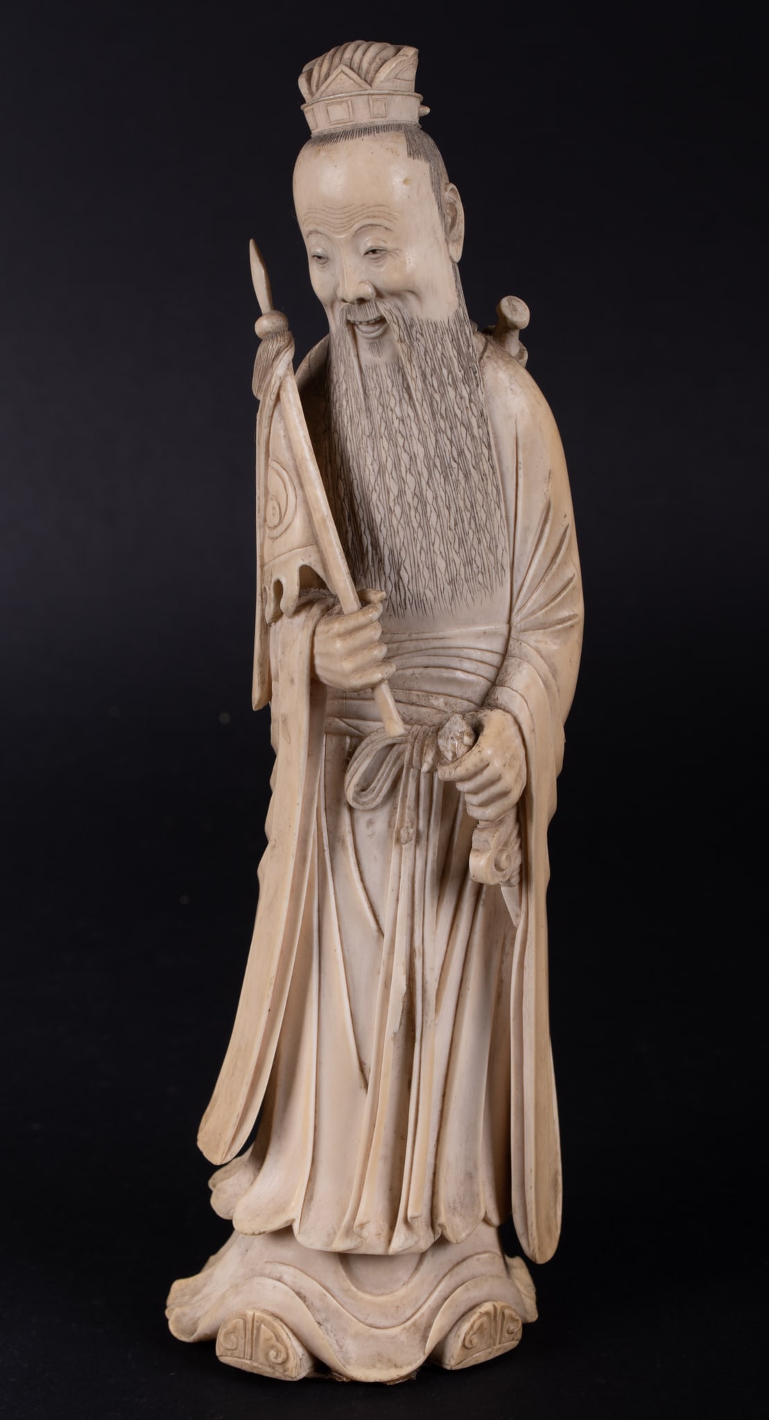 A Chinese Carved Figure of a Warrior: A Chinese Carved Figure of a Warrior A finely detailed carved bone figure of a warrior, the figured holding a banner and weapons, the face beautifully carved with a long flowing beard. 9 1/2 inches ta