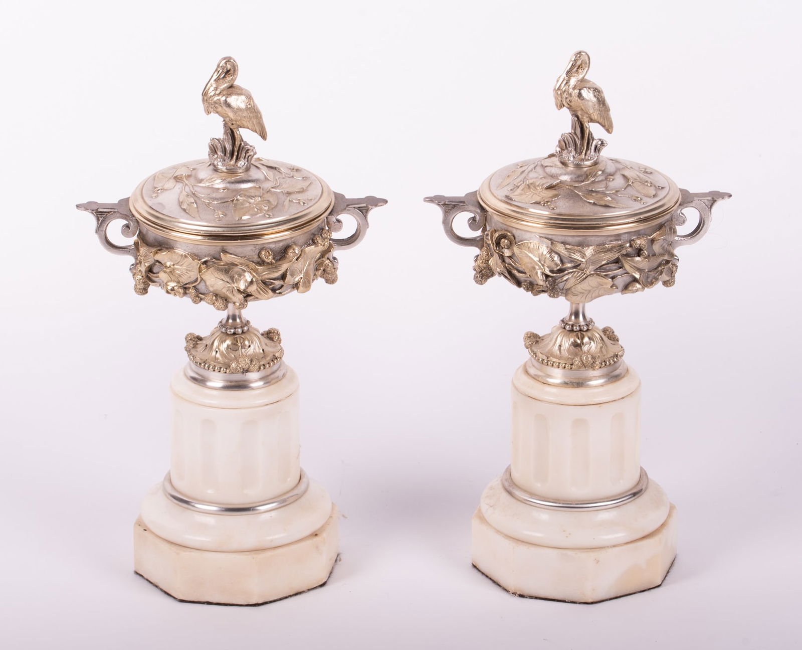 A Pair of French Antique Marble and Silvered Bronze Cassolettes: A Pair of French Antique Marble and Silvered Bronze CassolettesFrance, 19th century, in the Aesthetic Movement style with white marble shaped bases and silvered bronze covered tops. Vines circling the