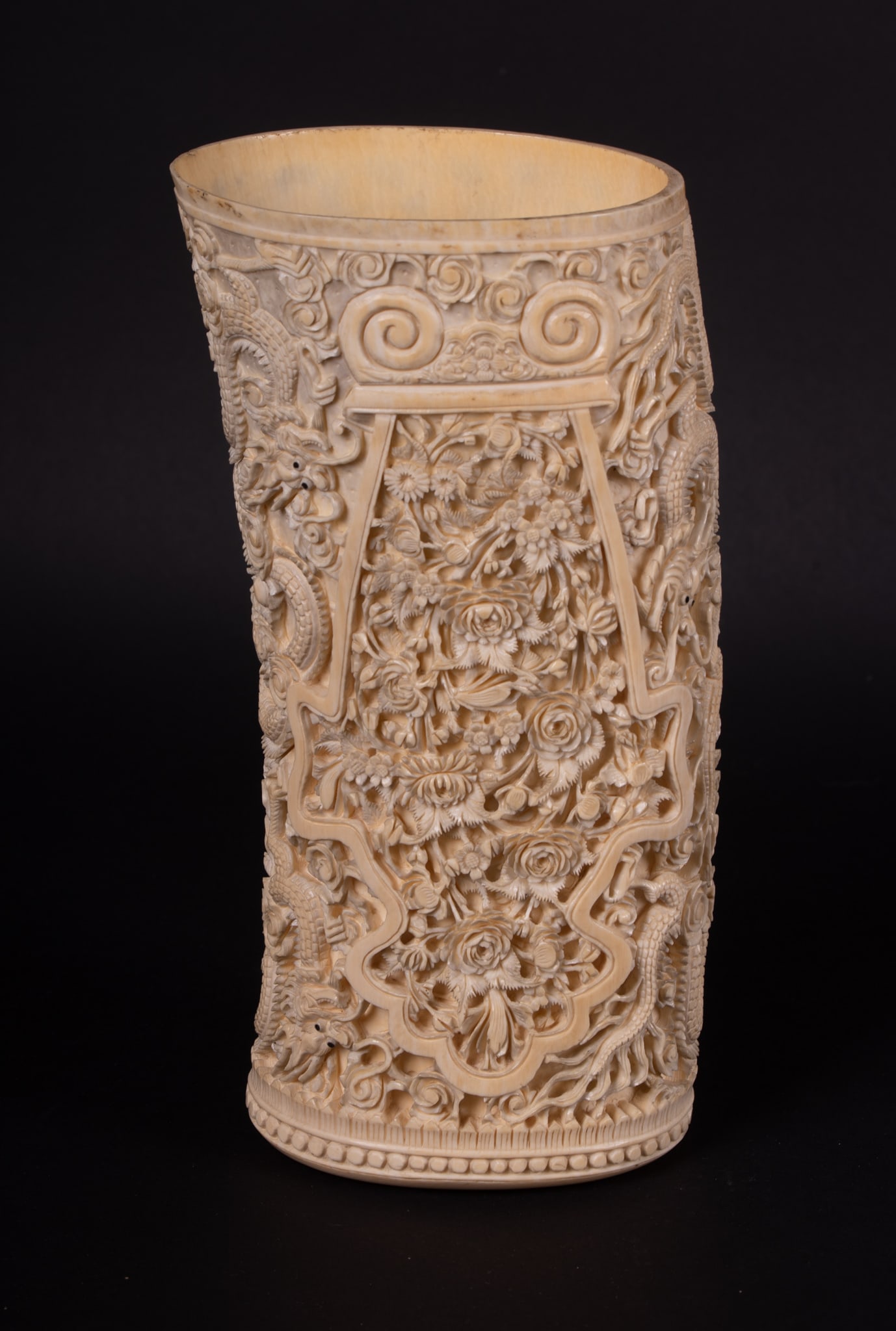 A Chinese Carved Tusk of Lavish Flowers and Fierce Dragons: A Chinese Carved Tusk of Lavish Flowers and Fierce Dragons A rather extraordinary carved tusk, the entire length of both sides finely carved with lush panels of blooming flowers, each end-side carved 