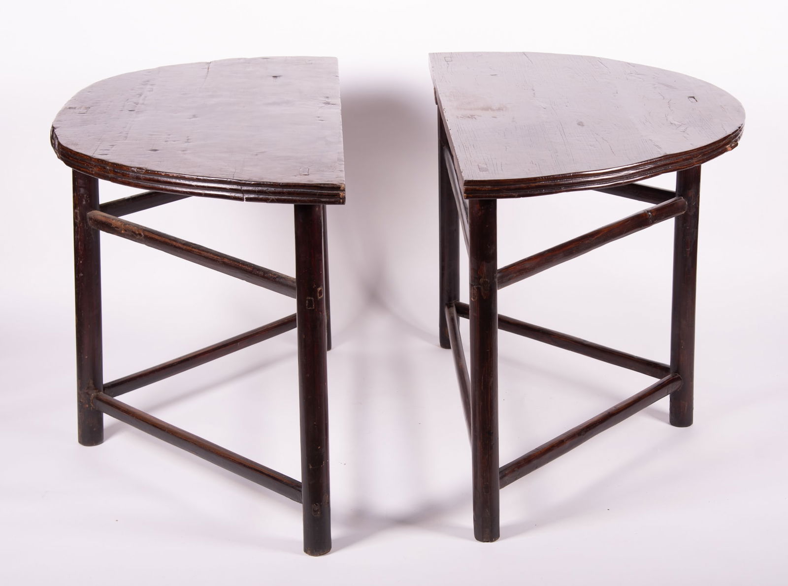 Pair of Asian Console Tables: Pair of Asian Console TablesDemi-lune tops and reeded edges, each raised on three tubular legs and stretchers.32 x 52 1/2 x 24 1/2 inches