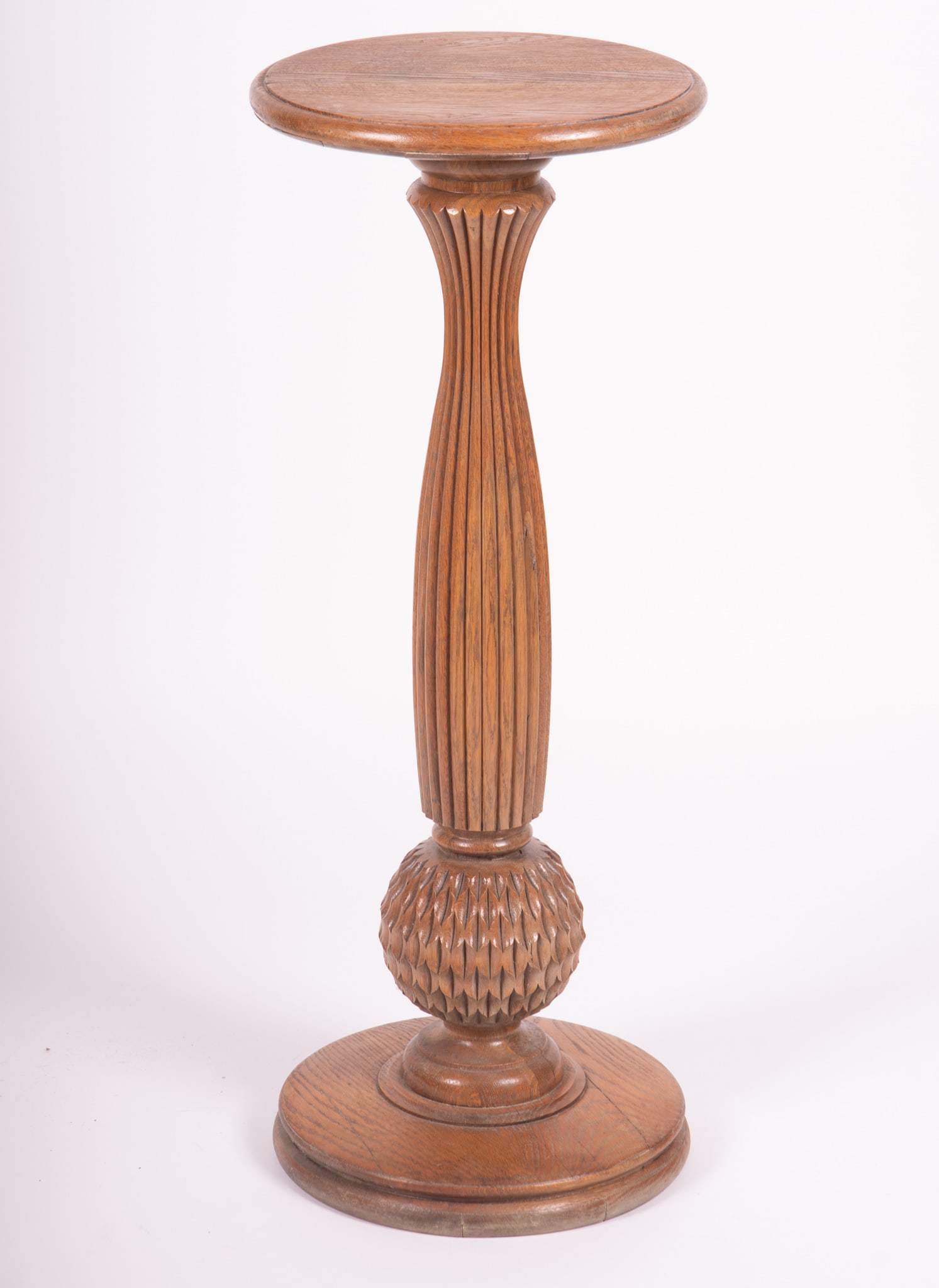 Carved oak wooden pedestal: Carved oak wooden pedestal circular top above a graceful fluted vasiform and shaped orb form column resting on a circular platform. Provenance: The Estate of Diana Eley, St. Louis, MO 36 x 14 inches