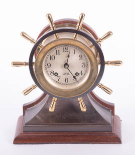 Chelsea Yacht Wheel Ships Bell Clock: Chelsea Yacht Wheel Ships Bell ClockBrass clock on brass base with wood plinth and back, 4 inch dialFrom the collection of Richard Langer.Height 10 1/4 inches, Width 8 3/8, Depth 4 3/8 inches