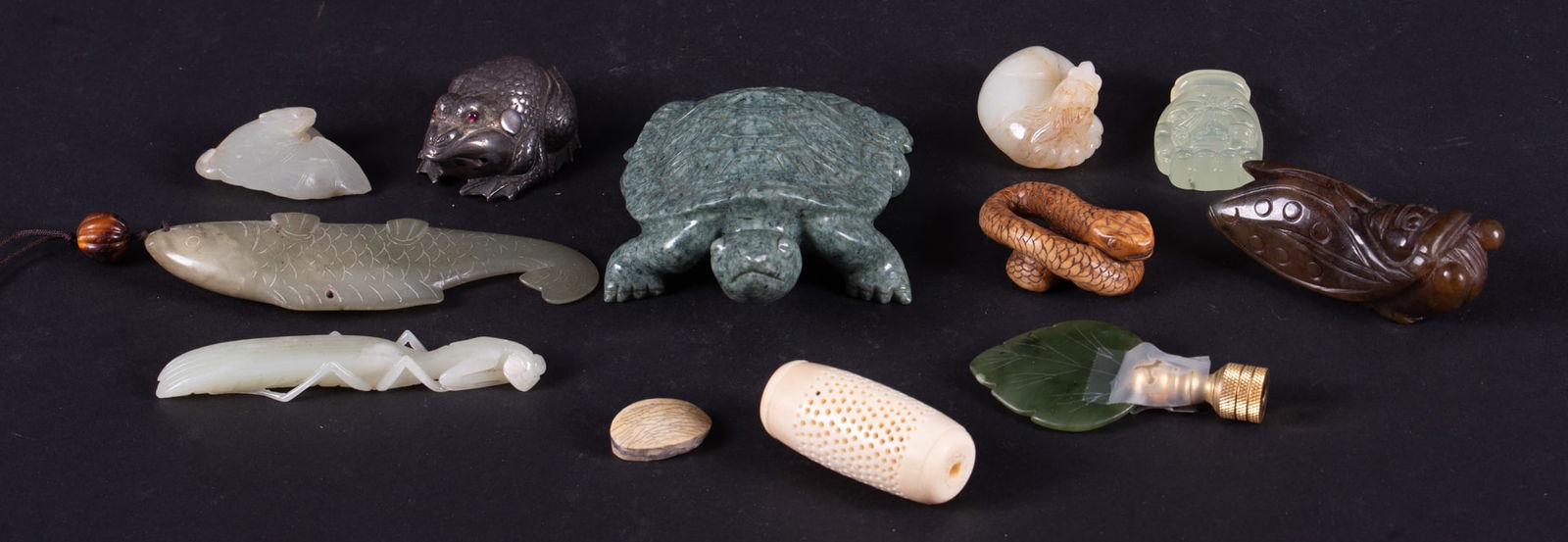 Twelve Chinese Decorative Objects: Twelve Chinese Decorative ObjectsThe lot includes several diminutive jade carvings of a praying mantis, horse, bat, cicada and fish; a carved stone turtle and carved snake.Provenance: The Estate of Di