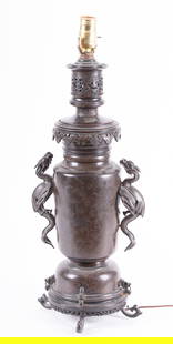 A Japanese Bronze Dragon Lamp: A Japanese Bronze Dragon LampJapan, Meiji period, a well crafted bronze lamp, the body with engraved floral designs, the sides with dragon handles. Originally an oil lamp, electrified later.Provenance