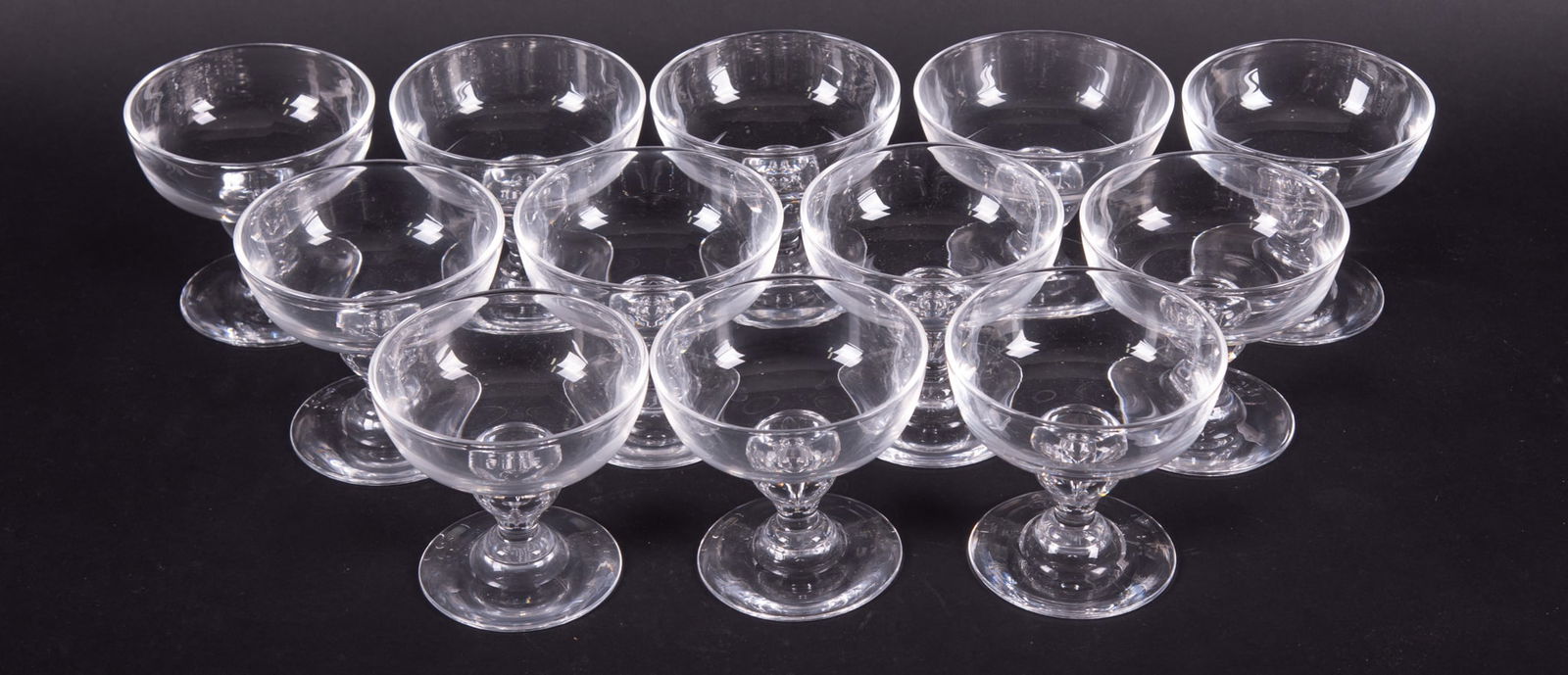 Twelve Bubble Stem Champagne Coupes, George Thompson for Steuben: Twelve Bubble Stem Champagne Coupes, George Thompson for SteubenCorning NY, a set of classic mid-century modern Steuben champagne coupes, design #7877. In original dust bags.3 3/4 inches tall, 4 inche