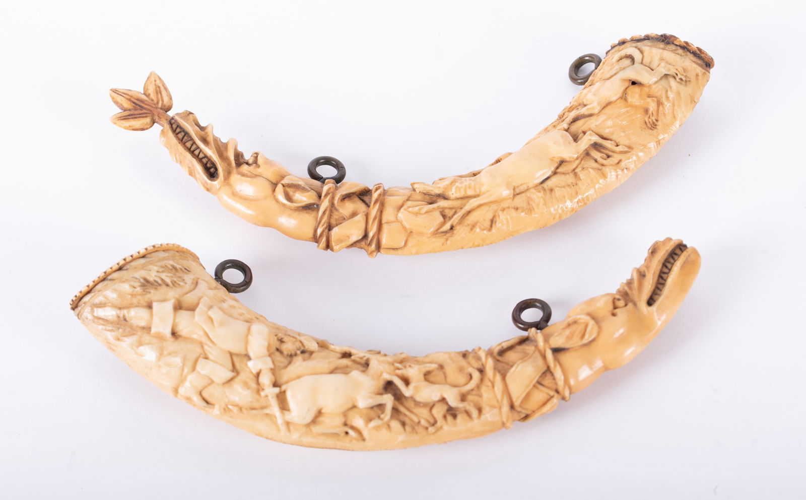 Two 18th Century Carved Bone Figural Animal Powder Flasks: Two 18th Century Carved Bone Figural Animal Powder FlasksThe diminutive horns carved with multiple animals and noble designs.Length of largest 7 3/4 inches