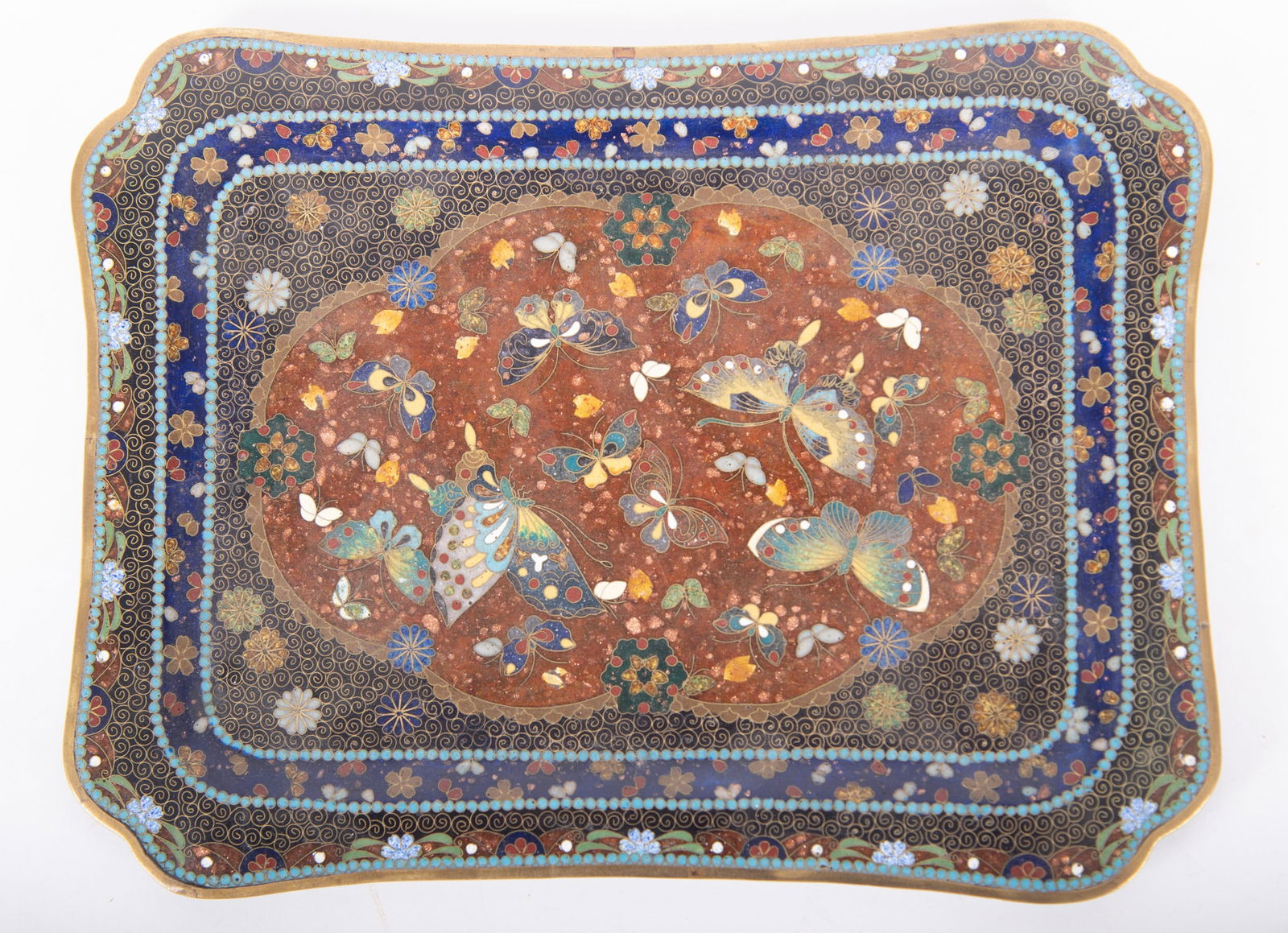 An Antique Japanese Cloisonne Tray: An Antique Japanese Cloisonne TrayJapan, Meiji period, a dresser tray with multiple butterflies within the gold-flecked shaped design.Provenance: The Estate of Diana Eley, St. Louis, MO10 inches x 7 3
