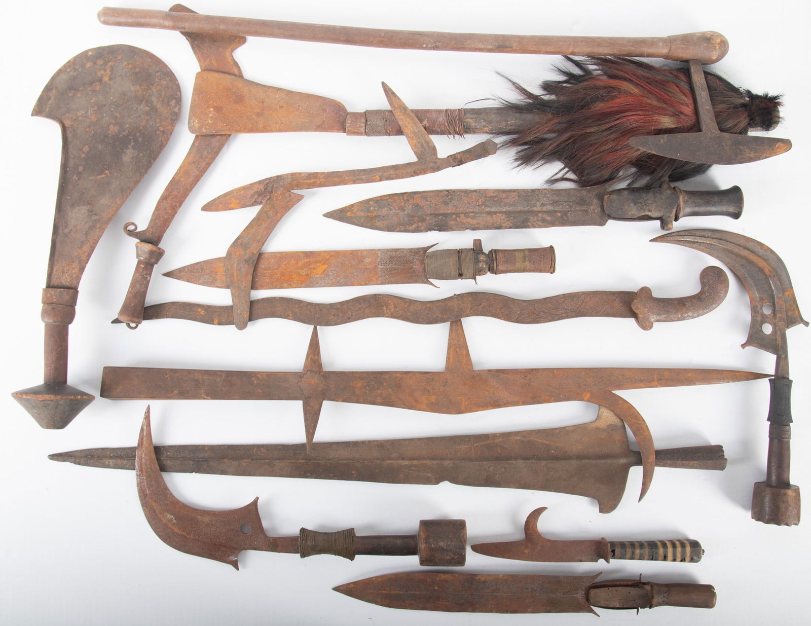Collection of Primitive Weaponry: Collection of Primitive Weaponryincluding various styles of swords, axes, daggers, scythes, and machetes; all with wooden handles. (14 pieces in total)overall dimensions: 38 x 17 x 5 inches