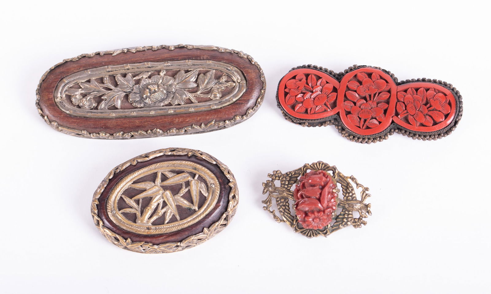 Four Antique Chinese Brooches: Four Antique Chinese BroochesThe largest of these brooches is 3 inches long and has a beautiful metal leaf framework embracing a wooden body with additional floral metalwork set in the center. Next we