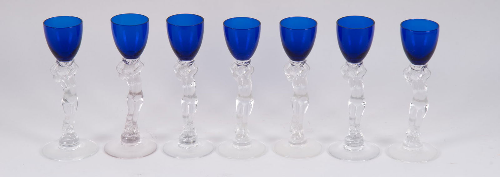 A Set of Seven Cambridge Royal Blue Nude Stem Liquor Cordials or Brandys: A Set of Seven Cambridge Royal Blue Nude Stem Liquor Cordials or BrandysOhio, Cambridge Glass Company, 7 Art Deco inspired female nude stem glasses in cobalt Royal Blue color from the Cambridge Statue