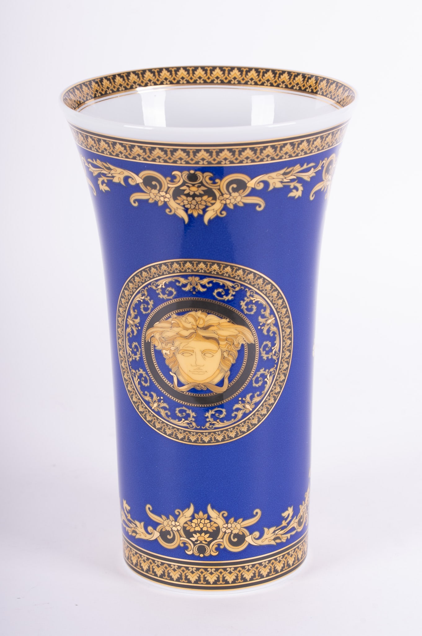 A Large Versace Medusa Blue Porcelain Vase by Rosenthal: A Large Versace Medusa Blue Porcelain Vase by RosenthalCreated by Rosenthal, the porcelain vase decorated with Versace's signature medusa in lavish gold decoration over a blue background. Marked: Rose