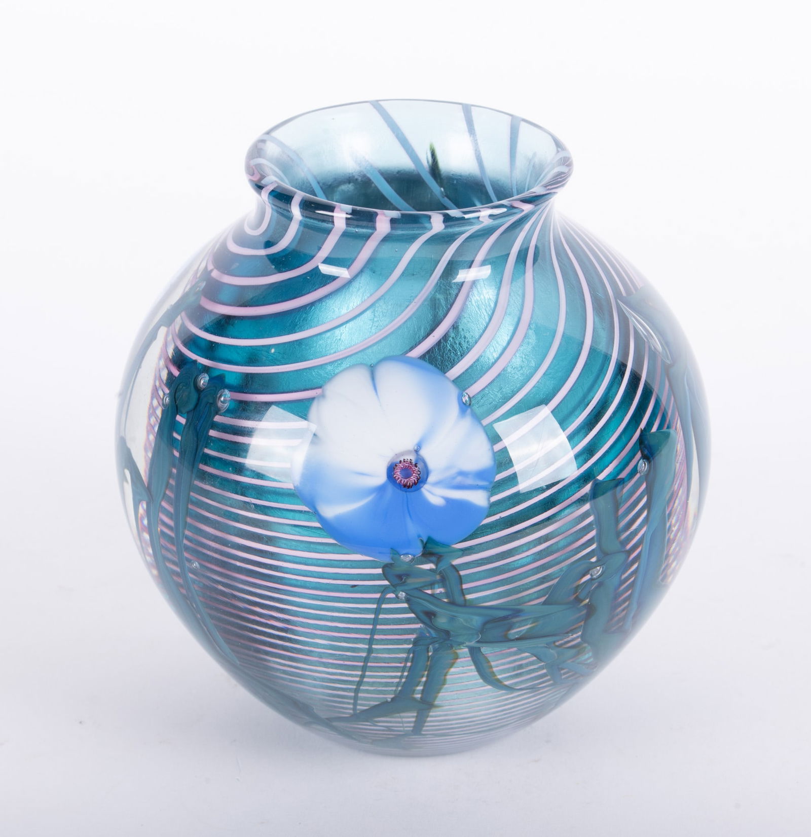 A Josh Simpson Floral Art Glass Paperweight Vase: A Josh Simpson Floral Art Glass Paperweight VaseAn early Josh Simpson art glass vase, the floral design of the vase set against a swirled design with an iridescent interior.5 x 5 3/8 inches