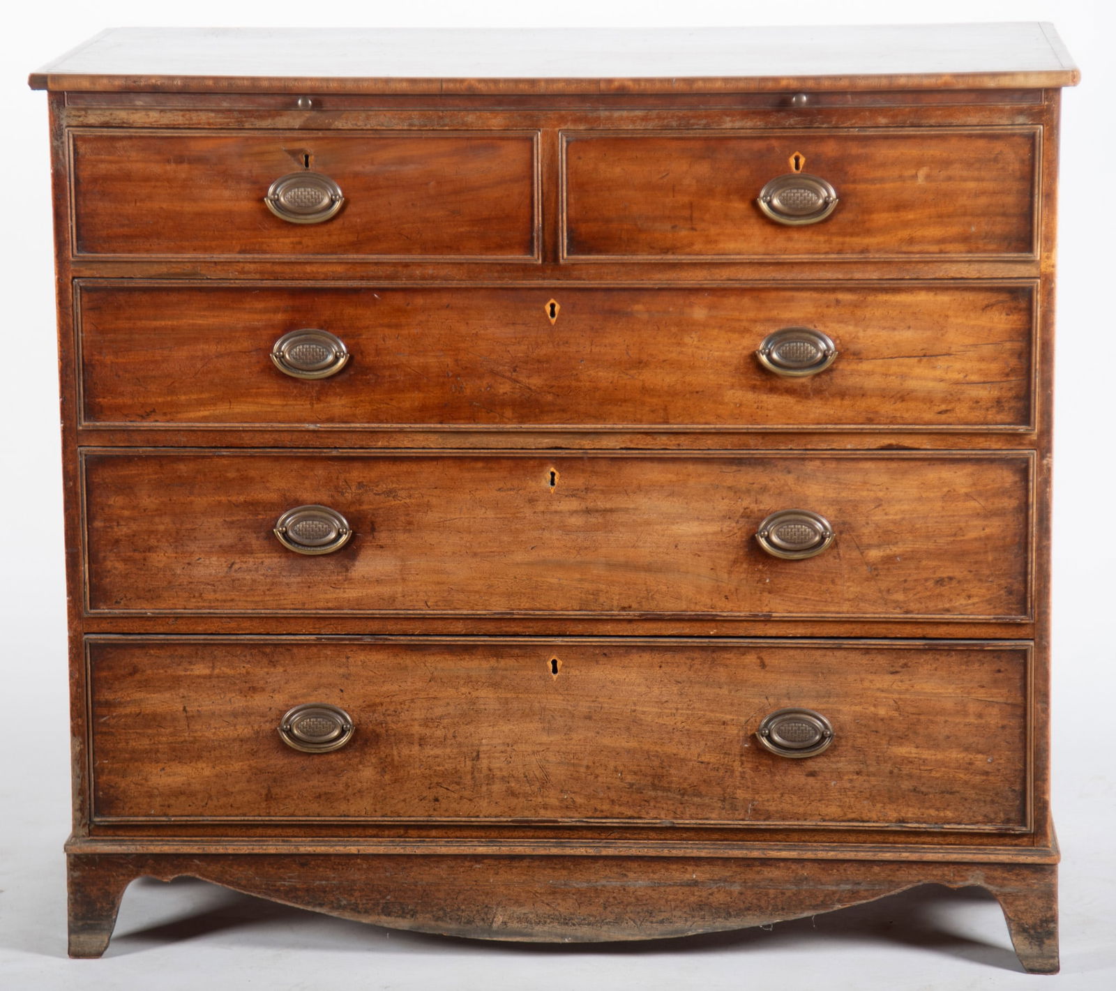 Antique English Georgian Chest Of Drawers: Antique English Georgian Chest Of DrawersCrossbanded tpp above a slide out writing surface and two short drawers above three long graduating drawers all with inlaid escutcheon and cockbeaded fronts al