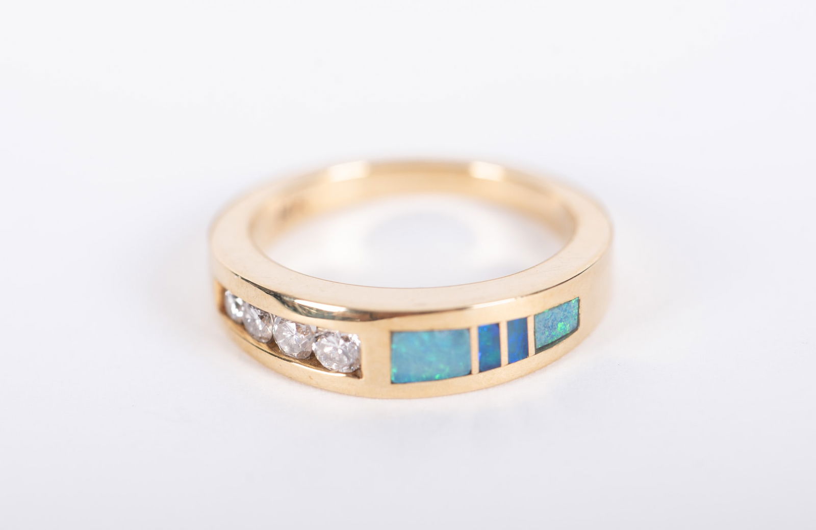 14K Yellow Gold Diamond & Opal Ring: 14K Yellow Gold Diamond & Opal Ring This stunning ring is channel set with 4 diamonds approximately .12 CTW and inlaid with 4 opals. It is size 6 and weighs 5.2g including stones. It is not signed,