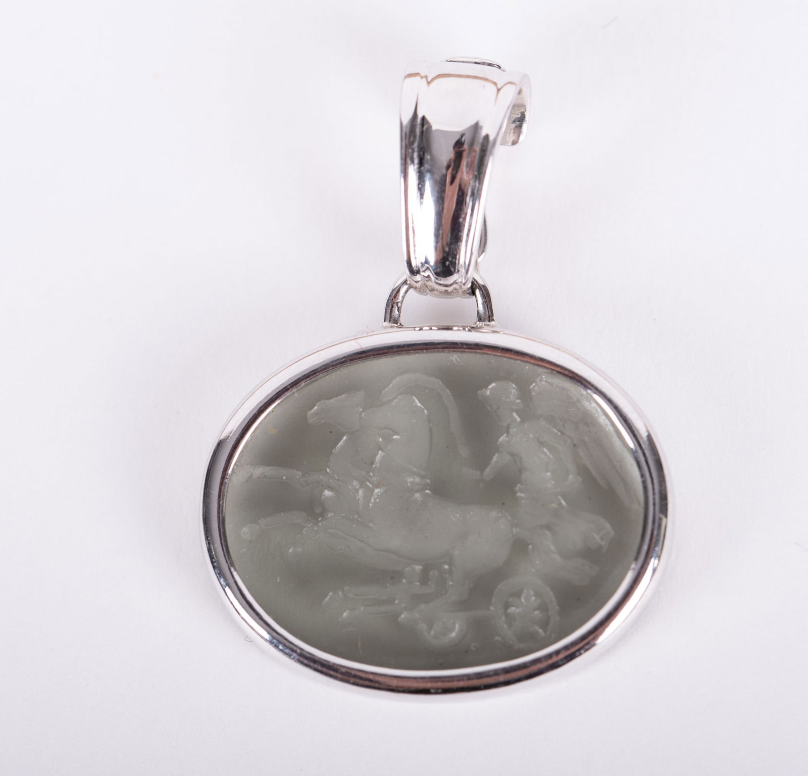 14K Italian White Gold Pendant with Intaglio Cut Crystal: 14K Italian White Gold Pendant with Intaglio Cut Crystal The smokey crystal depicts a mythological figure, possibly Helios, with a chariot drawn by two horses. It measures 1 inch by 3/4 inch. Clasp