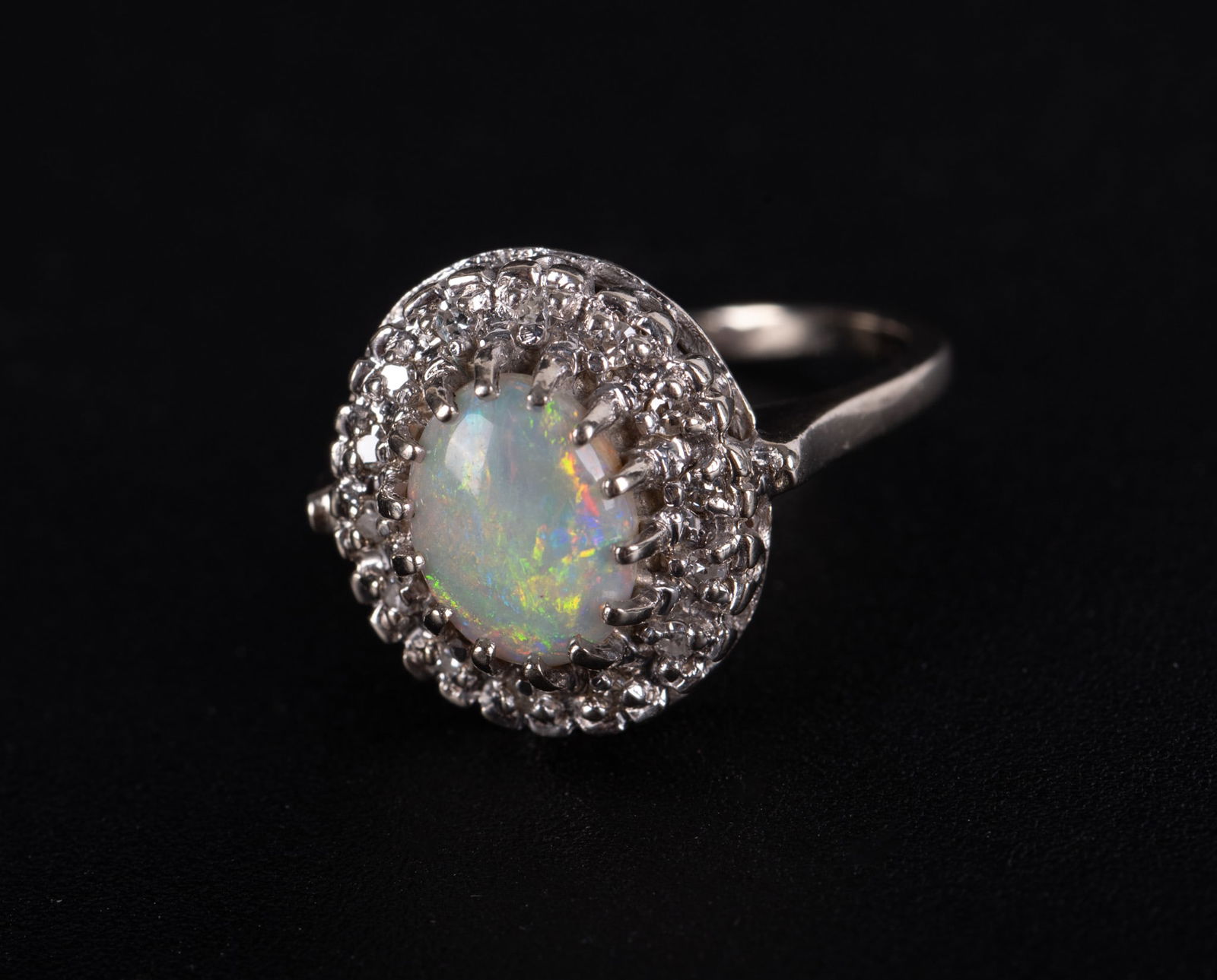 Ladies Opal, Diamond and 14K White Gold Ring: Ladies Opal, Diamond and 14K White Gold Ring Halo diamonds surround oval opal; opal 6.90mm x 8.80mm. Ring size 6.