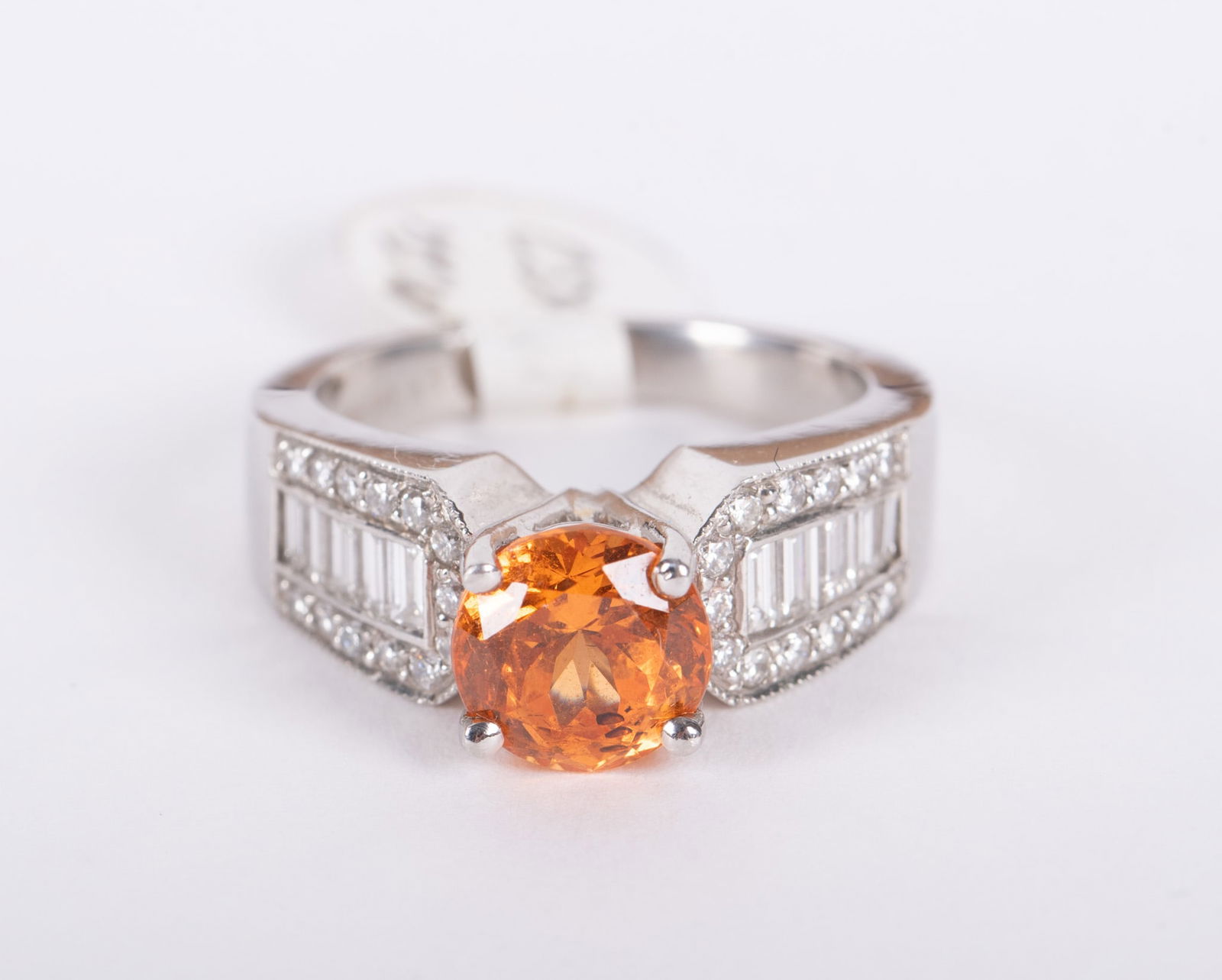 Garnet and Diamond Ring: Garnet and Diamond Ring ring with large orange garnet center stone set in platinum with baguette cut and round cut diamonds cascading down each side. 10 baguettes and 16 round cut diamonds total. 9.2