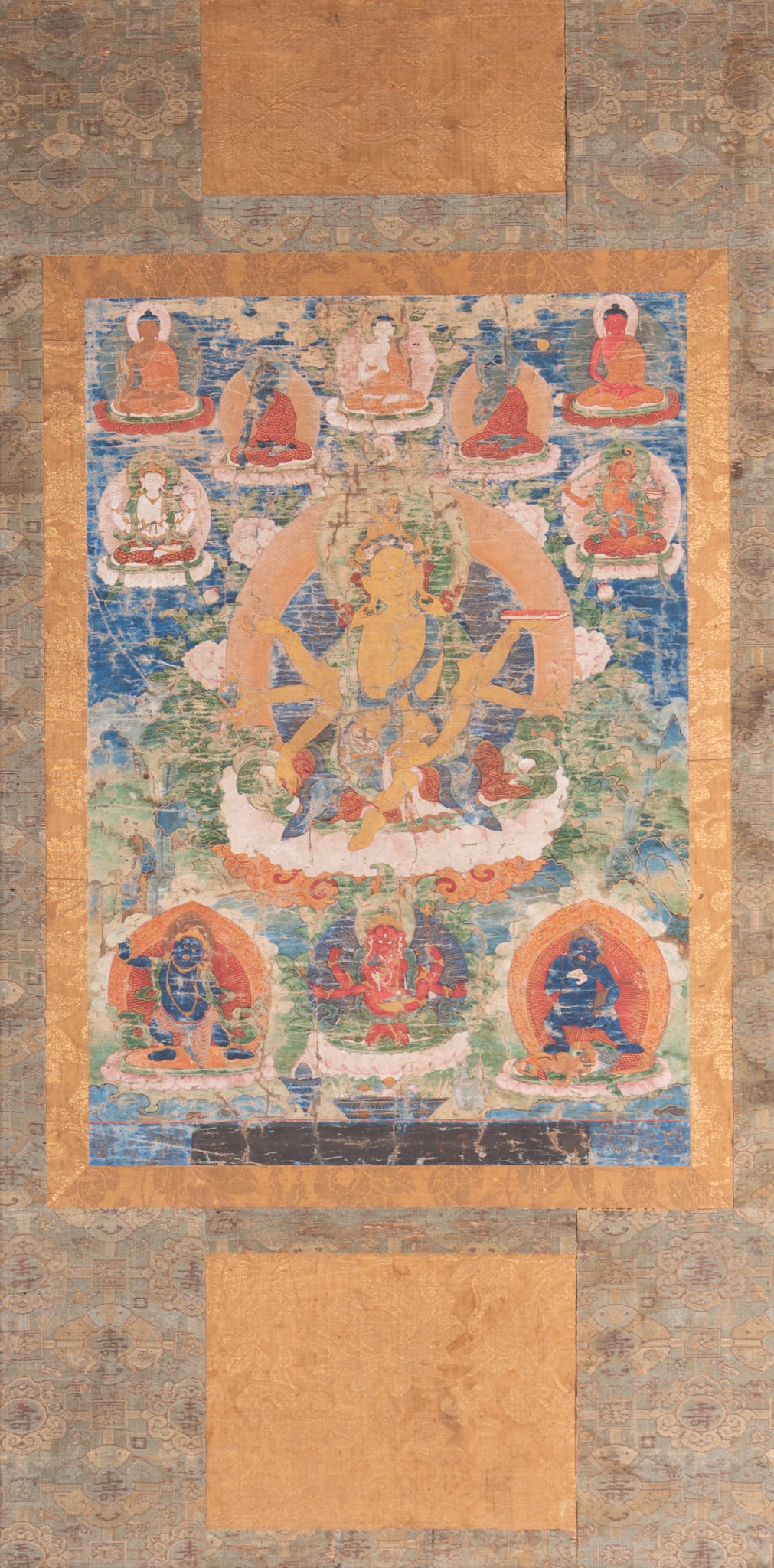 A Tibetan Thangka: A Tibetan Thangka Gouache on paper mounted on woven silk fabric, framed. Overall: 41 x 21 3/4 inches
