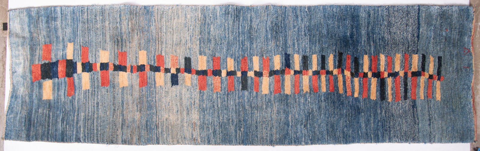 Contemporary Gabbeh Runner: Contemporary Gabbeh Runner The background has rows of blue shades with a central geometric design of red, tan and black shapes 2'7" x 8'11"