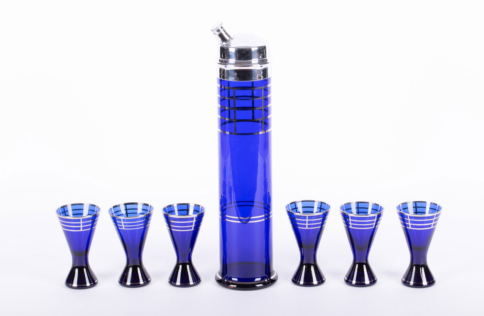 An Art Deco Cobalt and Chrome Skyscraper Cocktail Shaker and Glasses: An Art Deco Cobalt and Chrome Skyscraper Cocktail Shaker and Glasses Likely Hazel-Atlas Glass, the 15 3/4 inch tall cobalt cocktail shaker with chrome lid and chrome colored highlights to the body