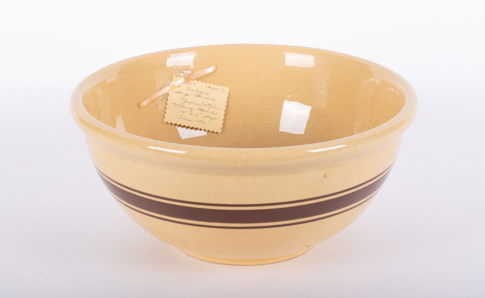 A Large Antique Yellow Ware Mixing Bowl with Banding: A Large Antique Yellow Ware Mixing Bowl with Banding Late 19th century, a large yellow ware pottery mixing bowl having a triple brown slip banding. 6 1/4 x 14 inches