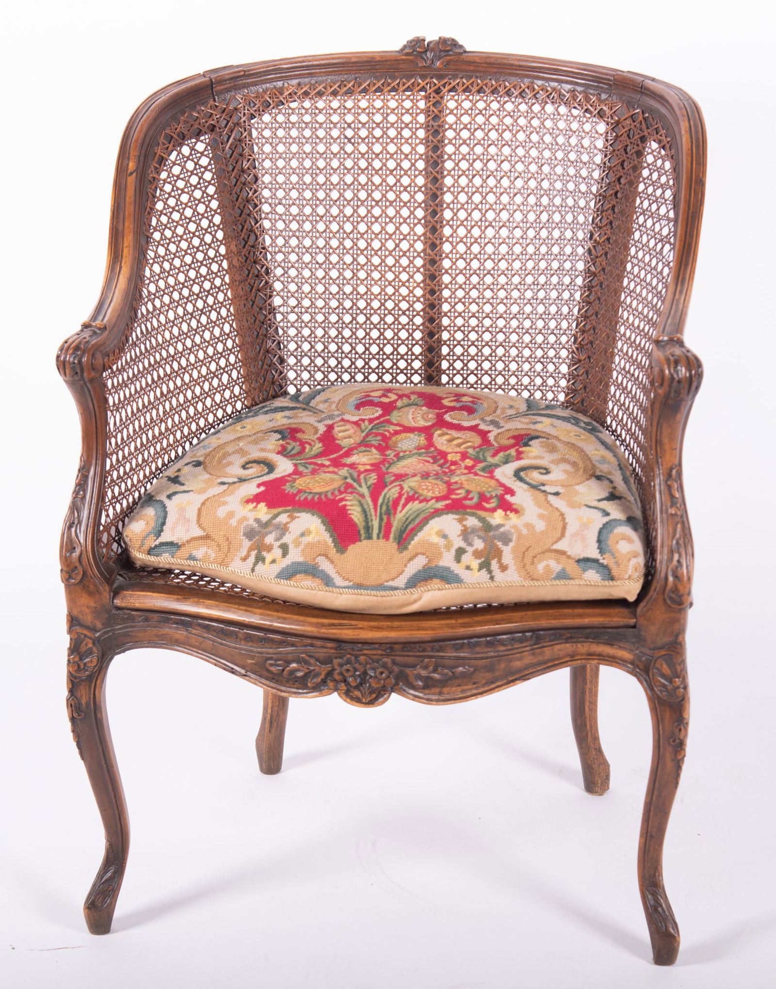 Antique French Louis XV Design Bergere: Antique French Louis XV Design Bergere Foliate carved head rail above caned back and sides centering a pair of carved arms with acanthus leaves The custom two-sided cushion of floral needlework and