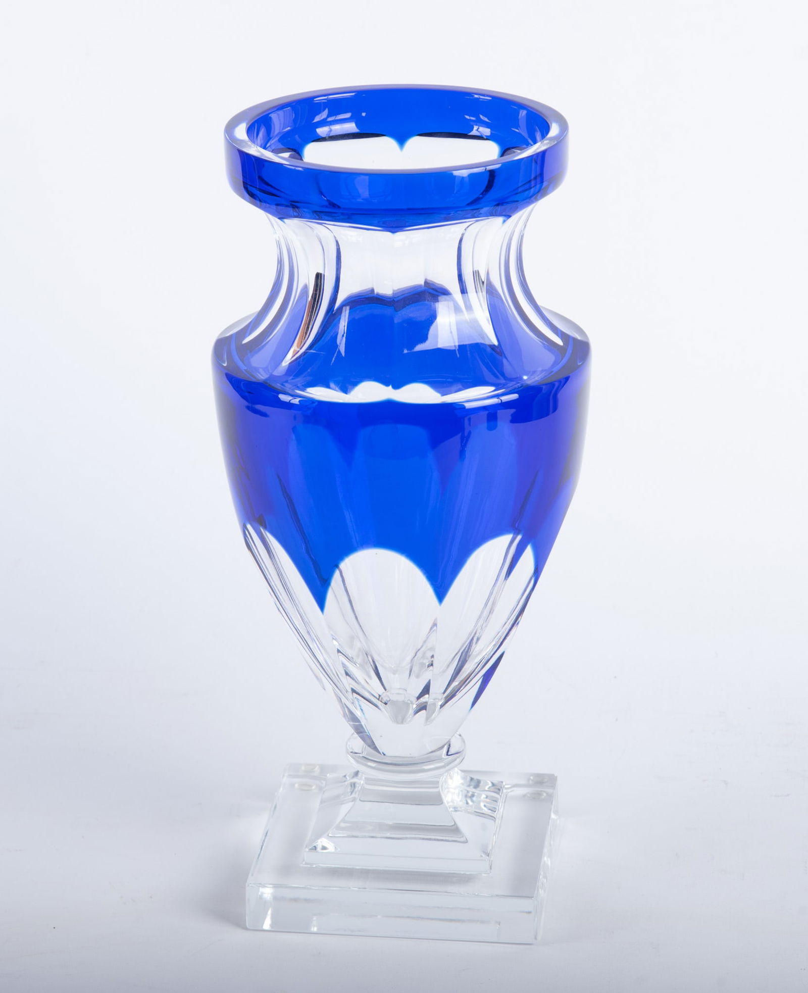 Cobalt Cut to Clear Vase: Cobalt Cut to Clear Vase A glass vase with an acrylic stand. Classic form with cobalt blue to clear with eight panels tapering to the bottom. Base measures 5 1/2 x 5 1/2 inches. 14 3/4 x 7 x 7 inches