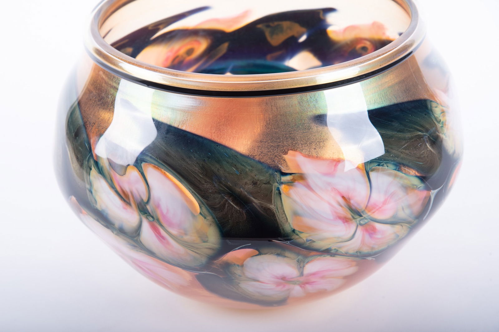 A Charles Lotton Oversized Multi-Flora Art Glass Center Bowl: A Charles Lotton Oversized Multi-Flora Art Glass Center Bowl American, 1992, an iridescent blown glass bowl with slightly curved neck with black collar, the waist of the large vessel decorated with