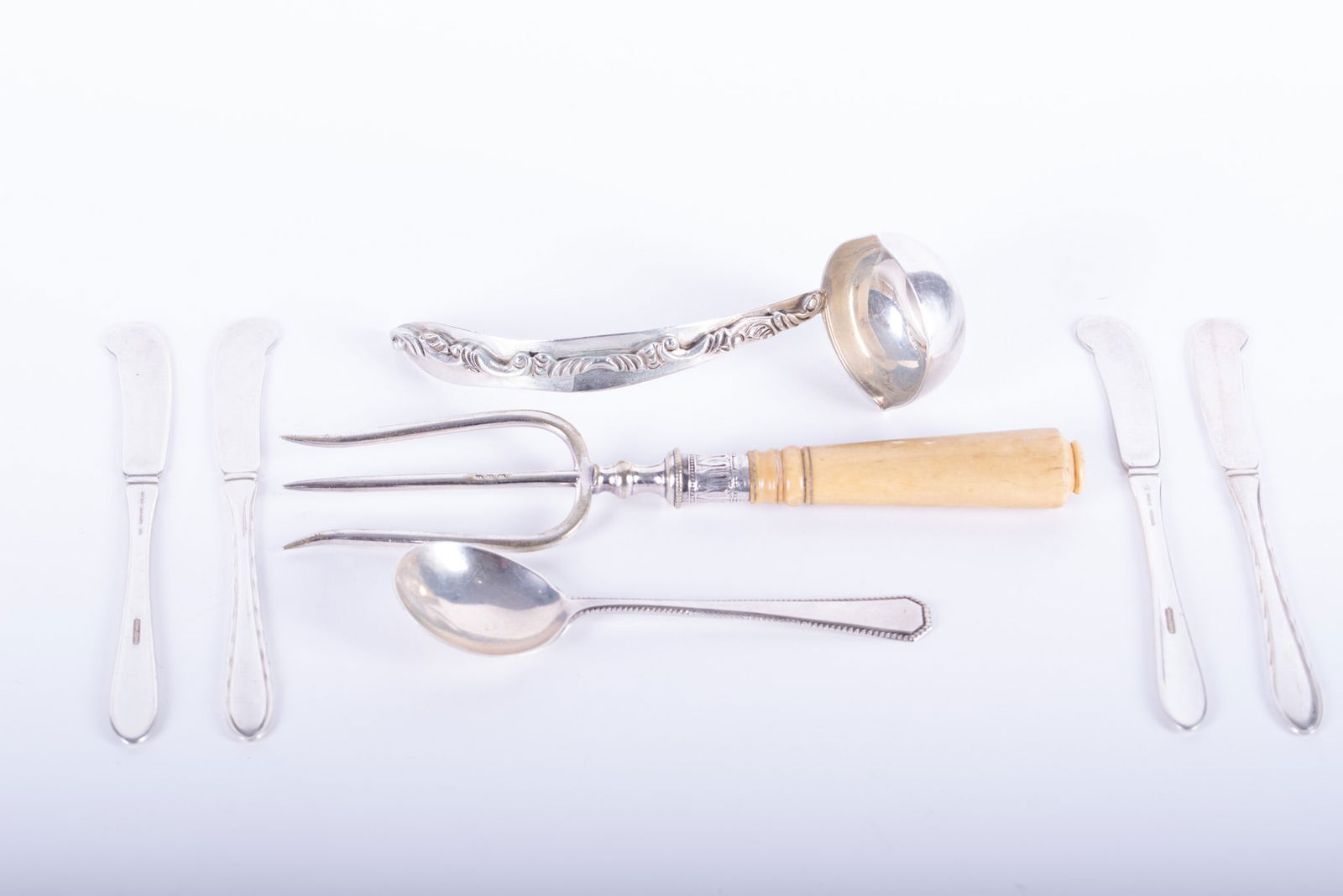 Collection of Sterling Silver Serving Pieces: includes a meat fork with a sterling bolster & bone handle-8 1/2 inches long, 4 butter knives-5 3/4 inches long, a sauce ladles-6 inches long, and a cream soup spoon-5 1/2 inches long. Weight