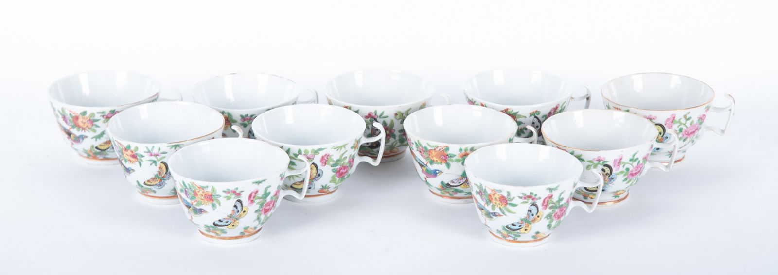 Eleven Antique Chinese Export Famille Rose Tea Cups: Eleven Antique Chinese Export Famille Rose Tea Cups China, Qing, 11 larger painted and enamel Famille Rose handled cups, each colorfully decorated with botanicals, flowers and an exotic bird. 2 1/2