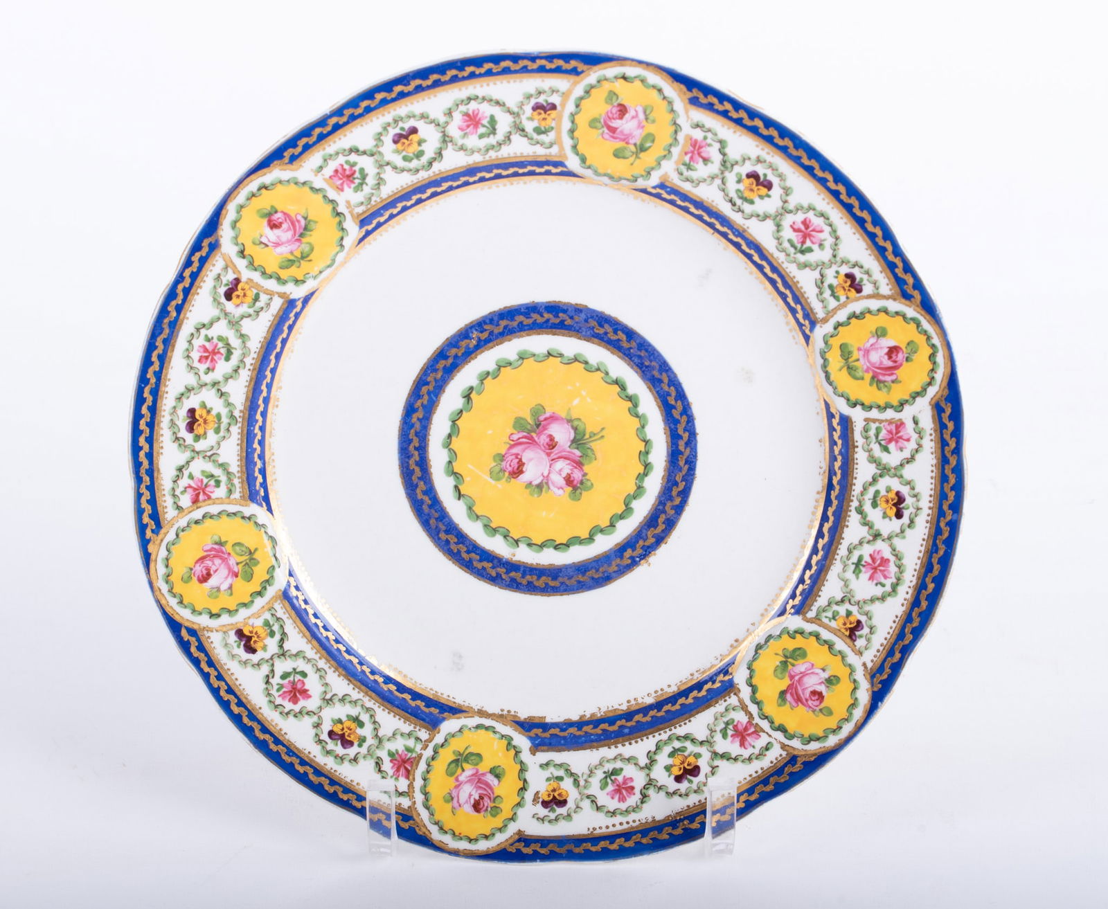 An Antique Sevres Porcelain Cabinet Plate: An Antique Sevres Porcelain Cabinet Plate France, likely 18th century, a finely decorated plate having floral paintings within a yellow cartouche, the borders of cobalt trim with floral painting