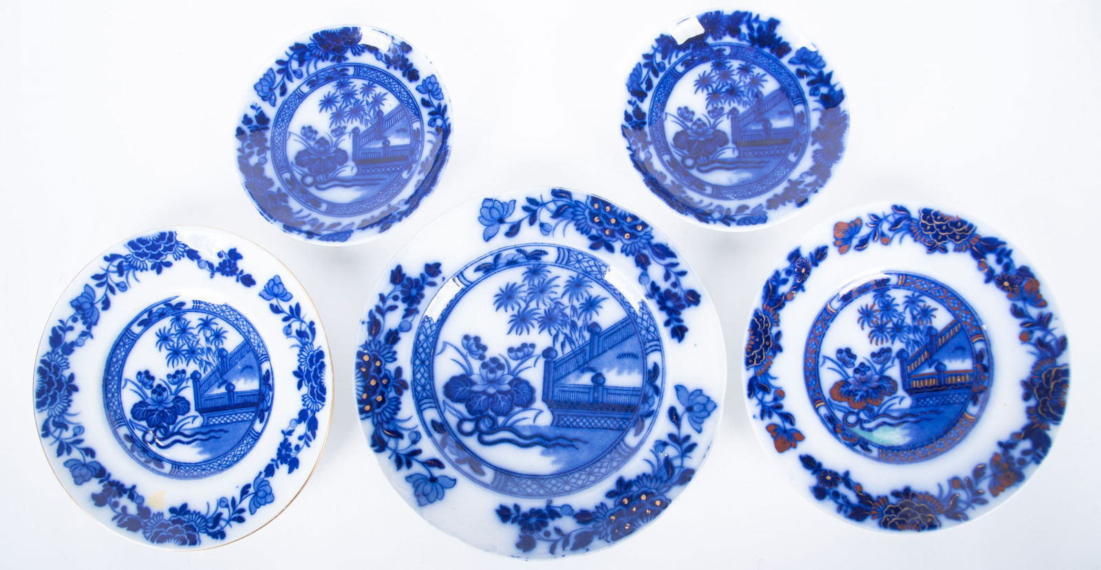 Five Staffordshire Flow Blue Table Items, Oriental by Samuel Alcock and Sons: Five Staffordshire Flow Blue Table Items, Oriental by Samuel Alcock and Sons England, circa 1840, the lot includes a pair of 5 3/4 inch saucer-form dishes, a 9 inch diameter plate with gilt