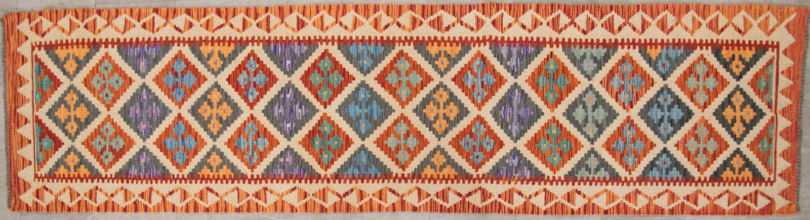 Handwoven Kilim Runner: Handwoven Kilim Runner The field with a multitude of diamond patterns in various colors of red, blue, cream and dark blue 2' &' x 9' 7"