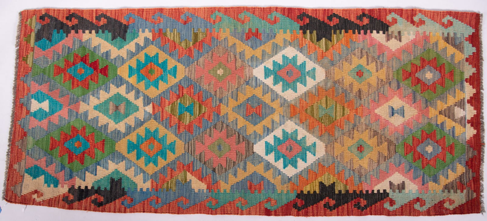 Hand Knotted Kilim Runner: Hand Knotted Kilim Runner The field of multicolored stepped and geometric diamond patterns in shades of green, red, orange and ivory. 2' 9" x 6' 2"