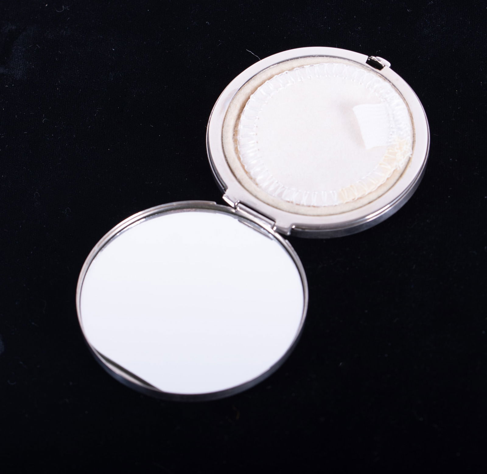 Tiffany & Co. Sterling Silver Compact: Tiffany & Co. Sterling Silver Compactmarked 925 sterling, with inner mirror and puff; original Tiffany bag. Total weight with mirror 2.325 troy ouncesDiameter 2 1/2 inches