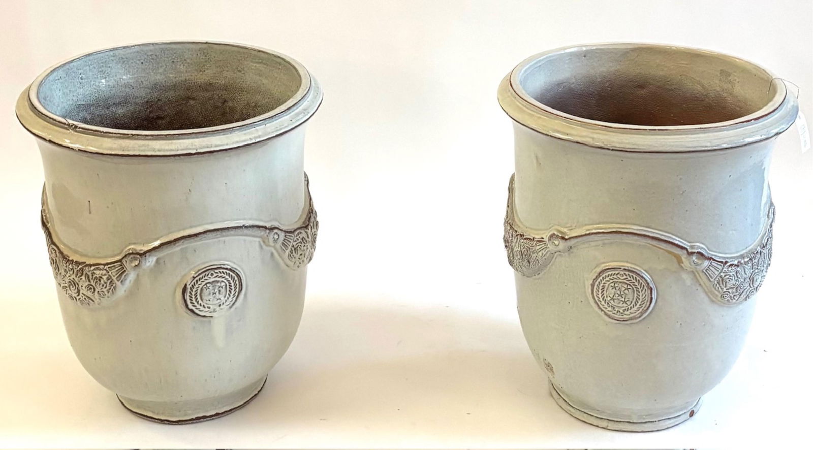 A Pair of Large Glazed Terracotta Garden Planters: A Pair of Large Glazed Terracotta Garden Planters Ivory glaze with raised circular medallions and floral swags Height: 24 inches