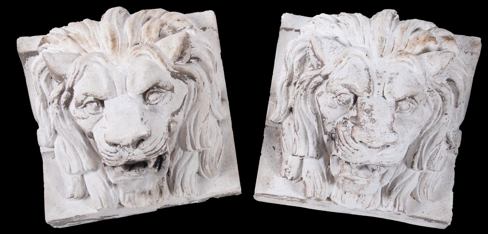 Pair of Sculptured Plaster Lion Heads: Pair of Sculptured Plaster Lion Heads Each lion head is on a square block base and each features a fierce expression with an open mouth. 13 x 15 1/2 inches
