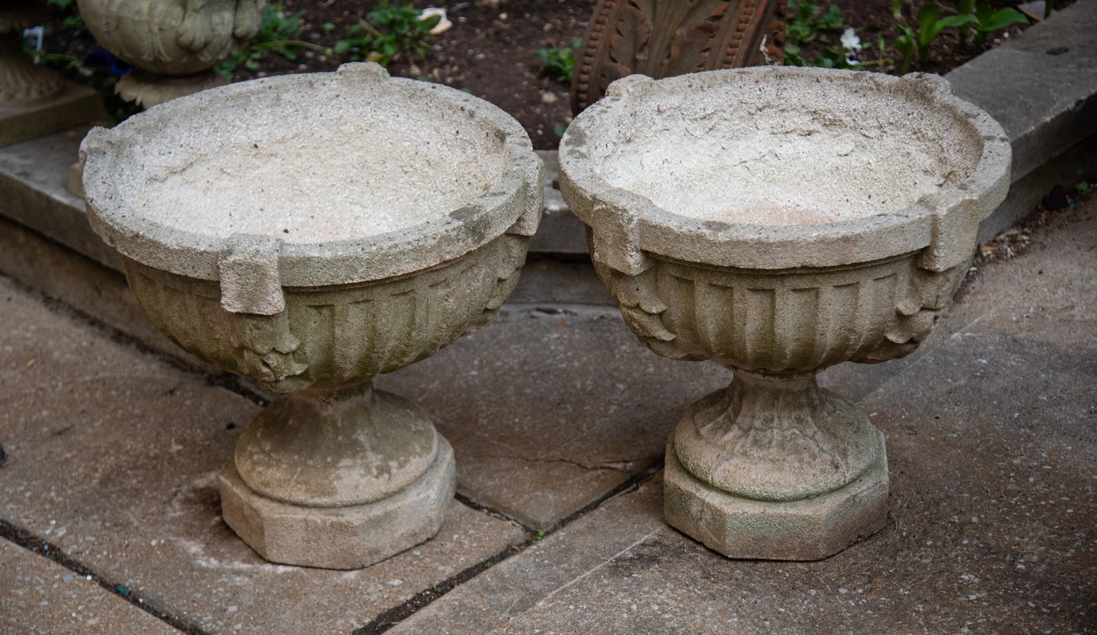 Pair of Neoclassical Style Fluted Concrete Garden Urns, Early 20th Century: Pair of Neoclassical Style Fluted Concrete Garden Urns, Early 20th Century The urns feature a fluted bowl with a decorative rim, supported by an octagonal base. 20 x 20 x 20 inches