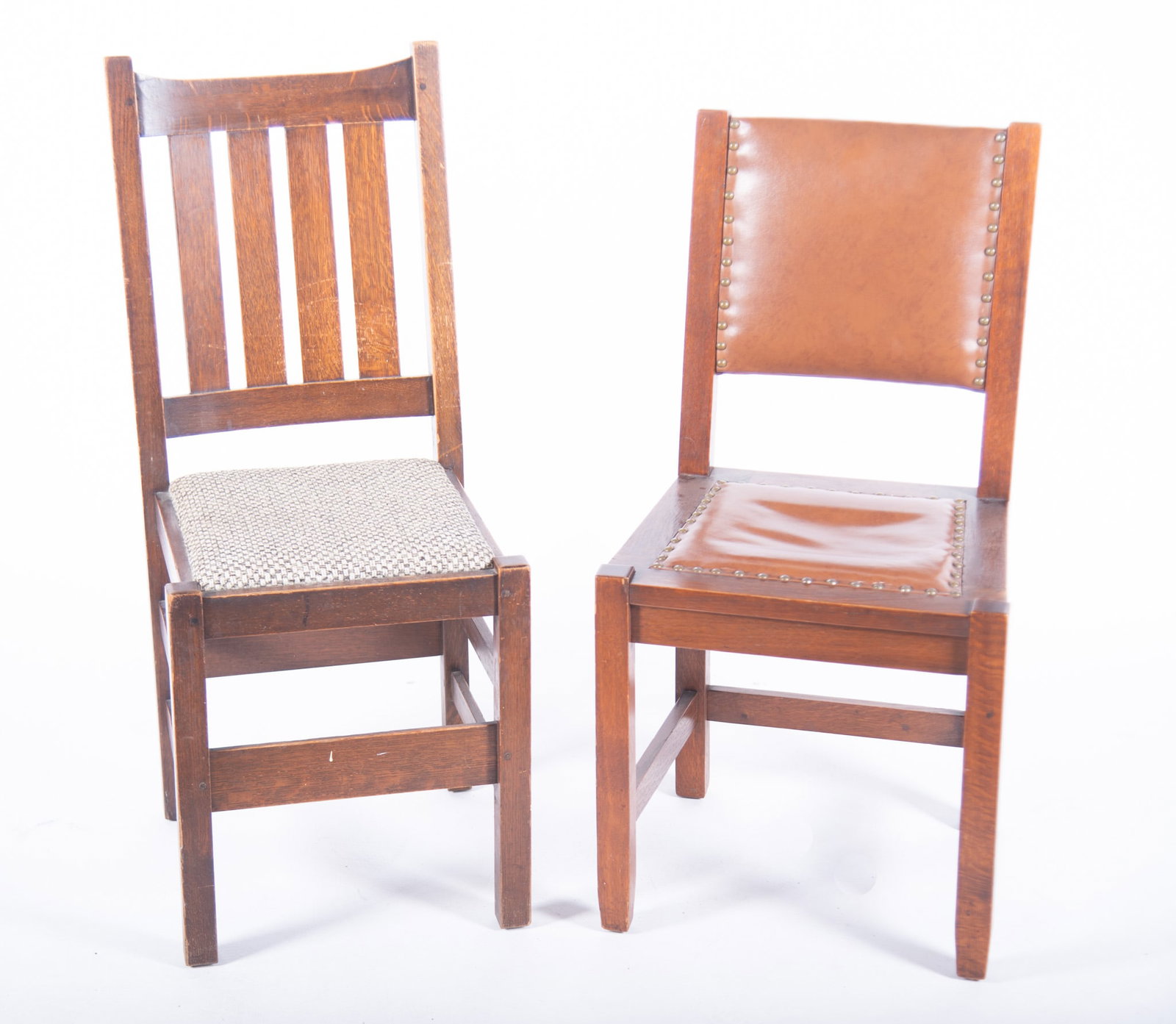 Two Associated Oak Arts And Crafts Side Chairs: Two Associated Oak Arts And Crafts Side Chairs One having a sloped head rail above four vertical slats above an upholstered seat and stretchers. The second having a leather tack upholstered back and