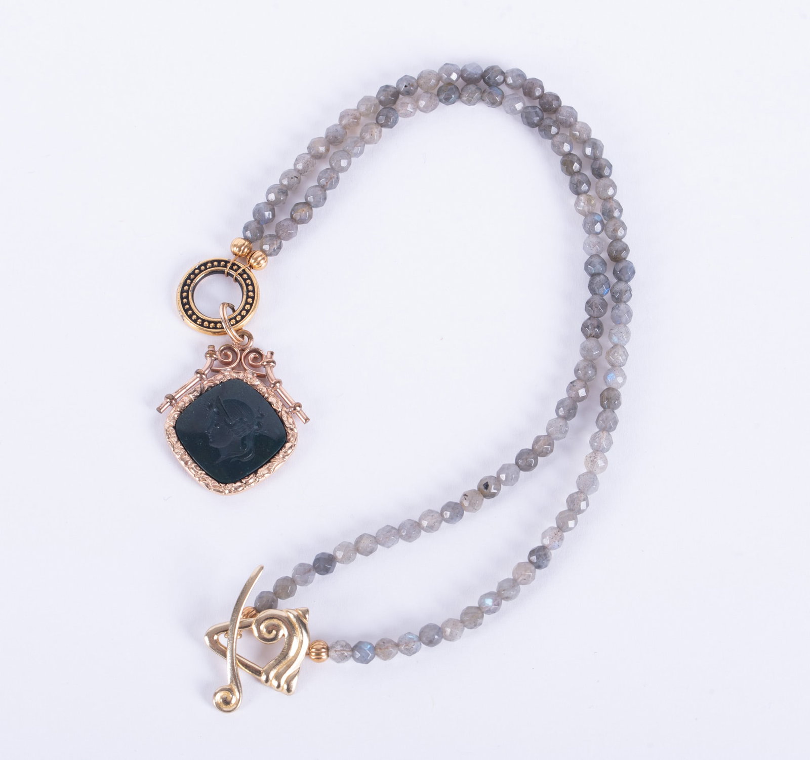 Watch Fob Necklace with Labradorite Beads: Watch Fob Necklace with Labradorite BeadsThe antique fob is an intaglio cut bust of a goddess carved into bloodstone. The mounting is gold filled. The labradorite beads are faceted and the length is 1