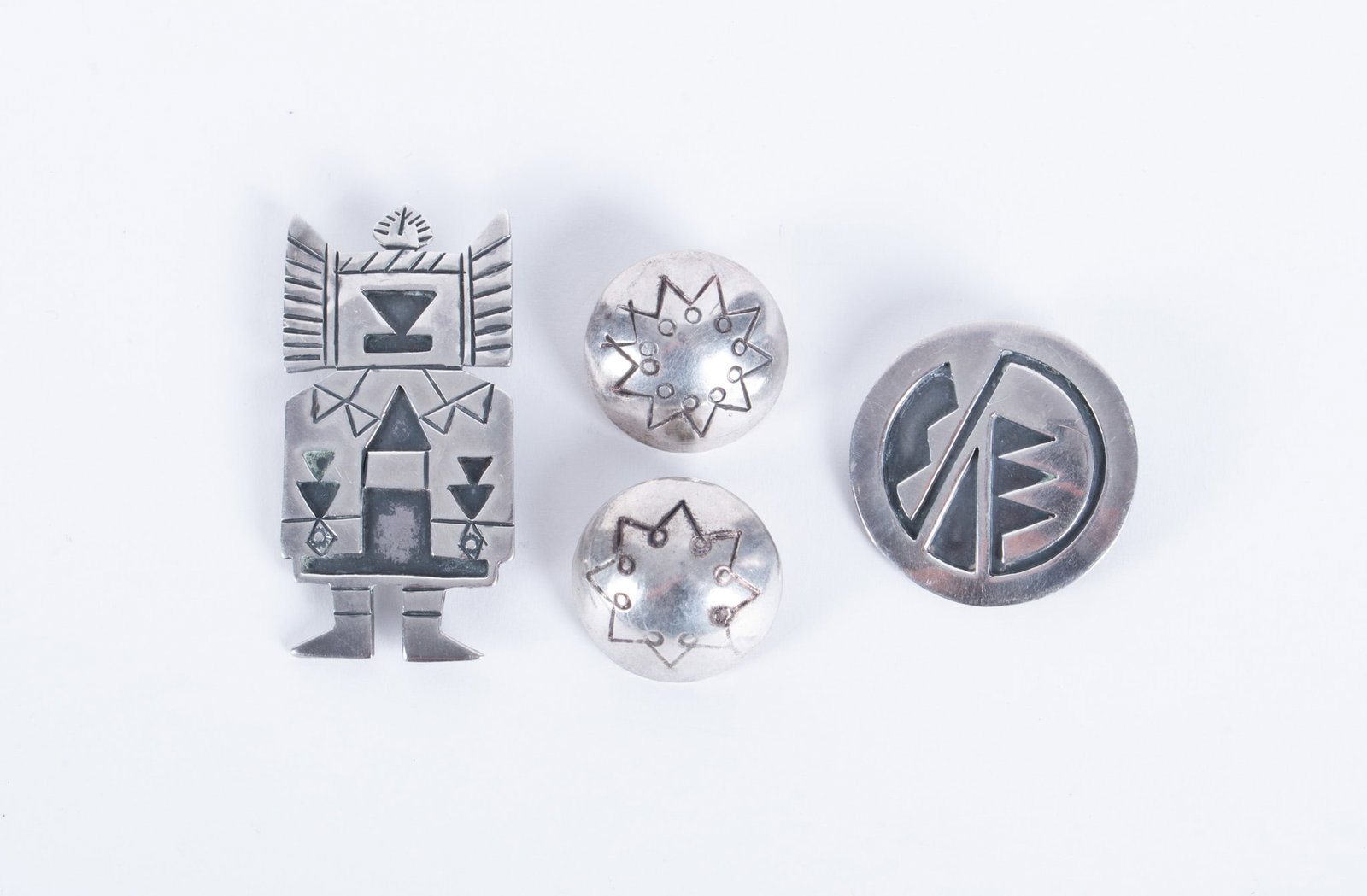 Vintage Native American Sterling Jewelry: Vintage Native American Sterling Jewelry This lot contains a 2 inch brooch depicting a Kachina figure, the circular piece is also a pendant and shows a stylized solar symbol as do the clip earrings.