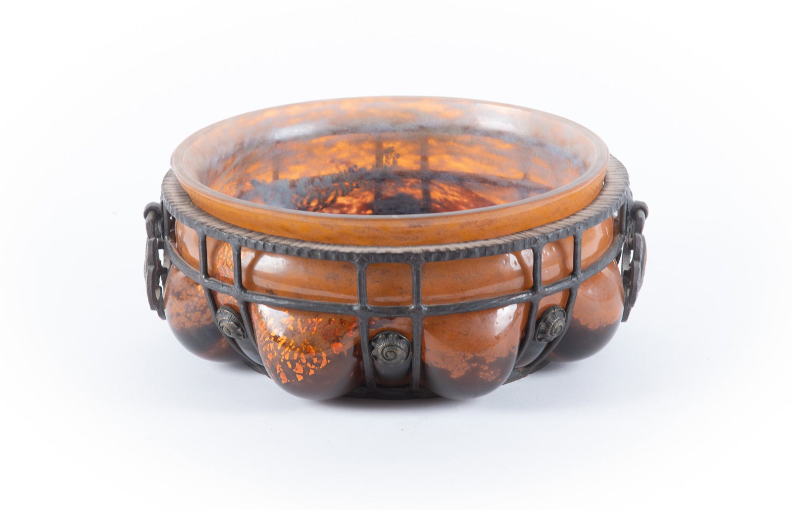 Daum Nancy and Louis Majorelle Wrought Iron and Glass Bowl: Daum Nancy and Louis Majorelle Wrought Iron and Glass BowlFrance, a mottled and foil-infused art glass bowl blown into a hand-forged iron "cage" or mount. Signed on the underside. The cage work featur